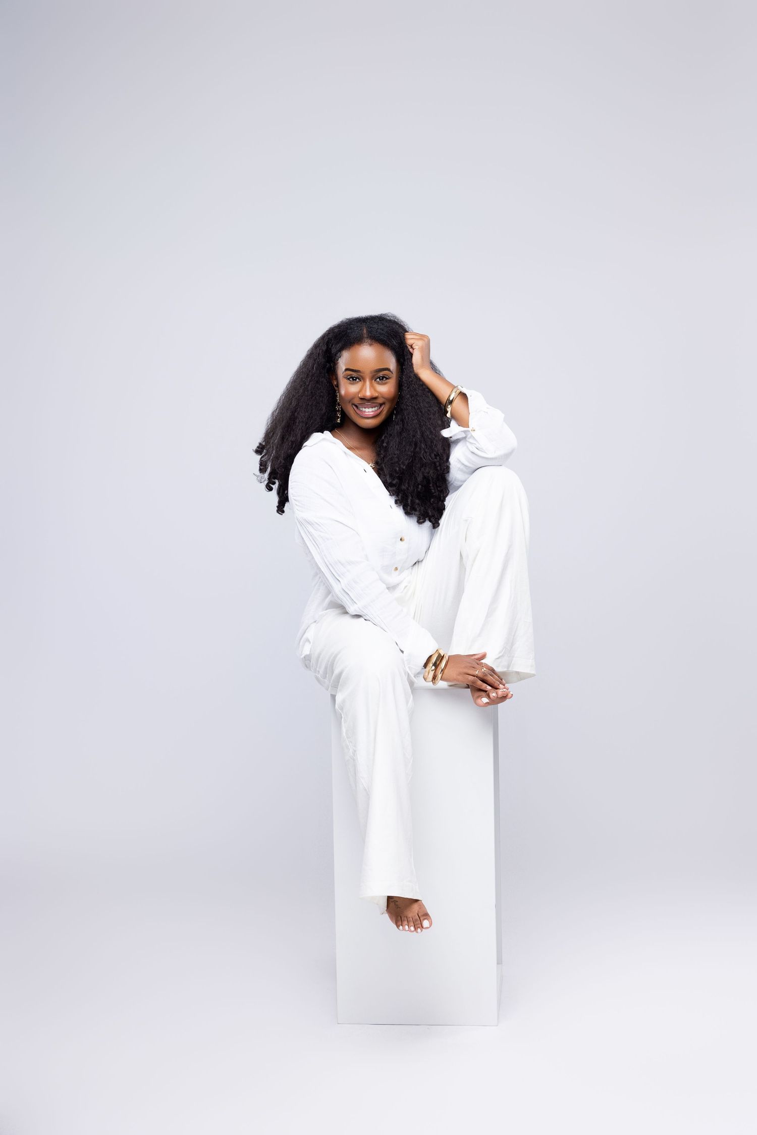 Professional portrait session in white clothing against minimal white background.