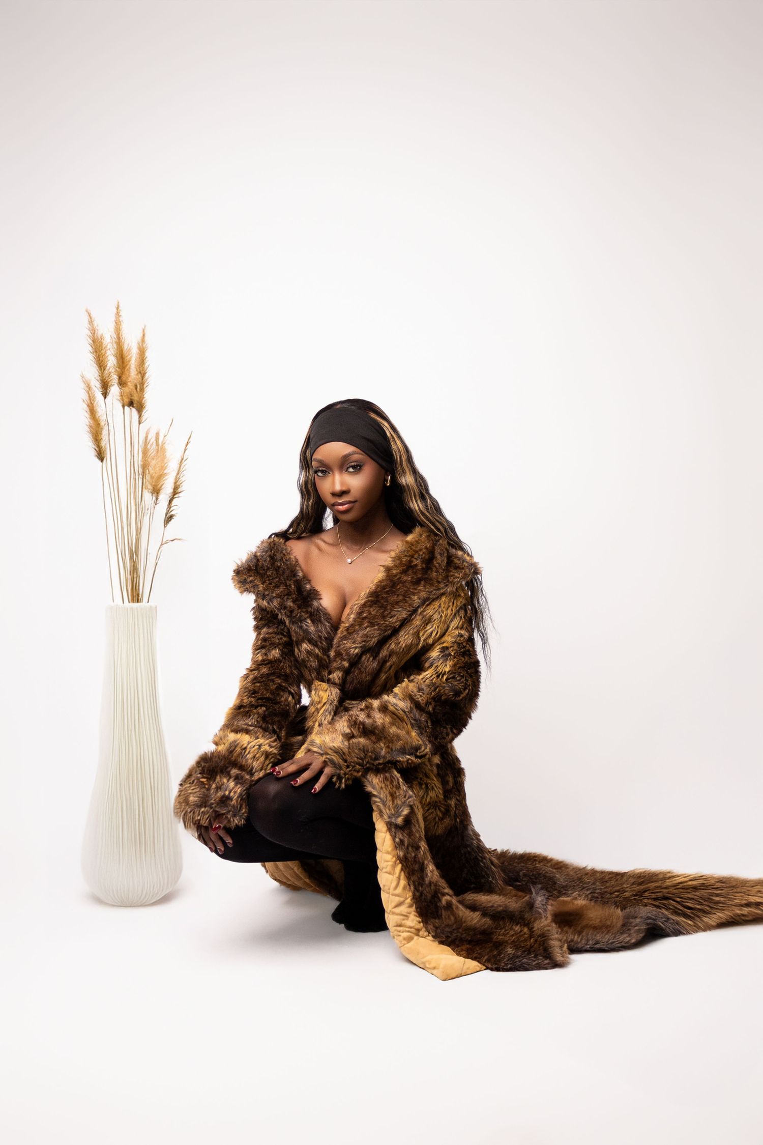 Luxurious brown fur coat styled with minimal decor and pampas grass arrangement.