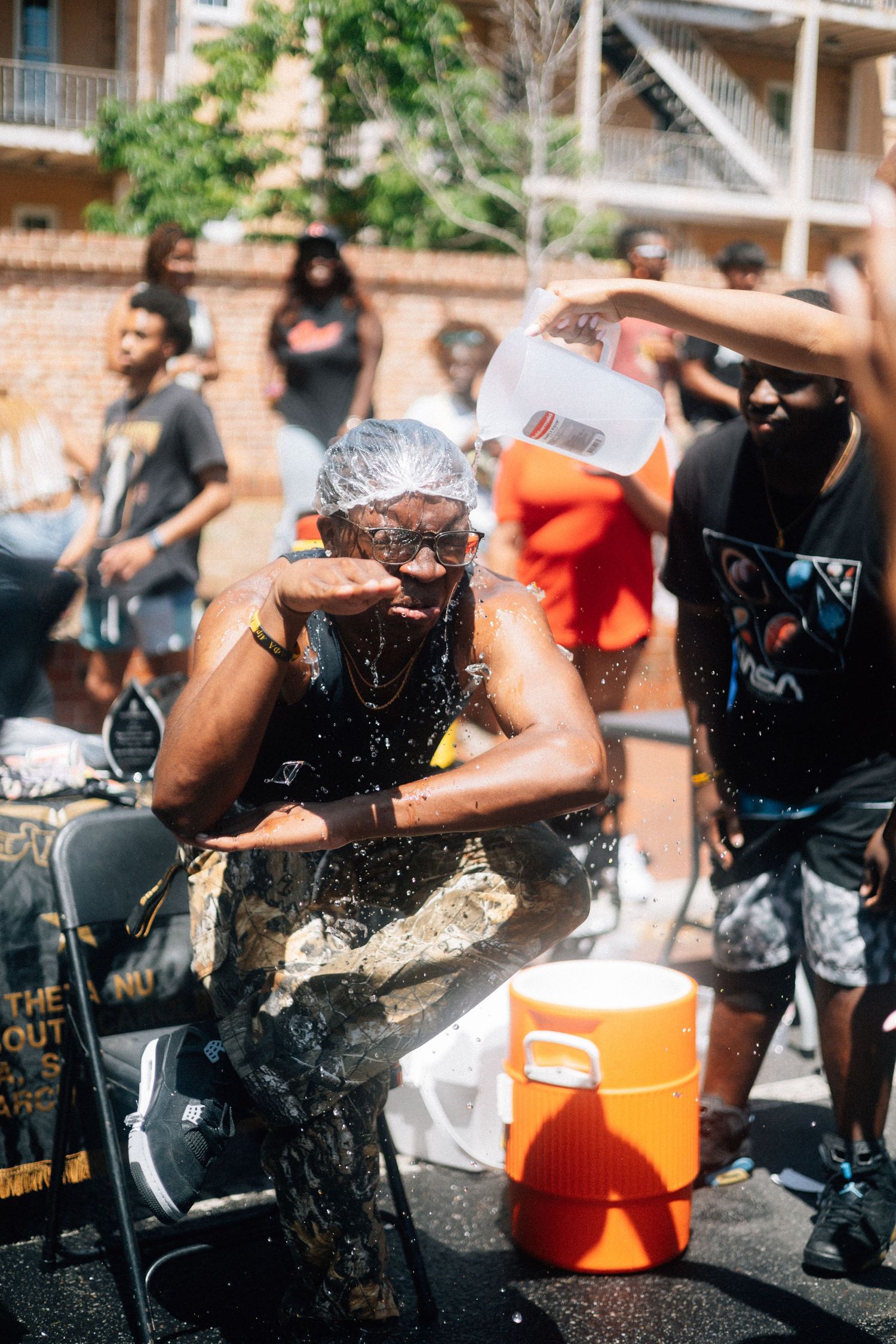 People cooling off getting splashed with water on a hot summer day during an outdoor gathering.USC Hip Hop Wednesday