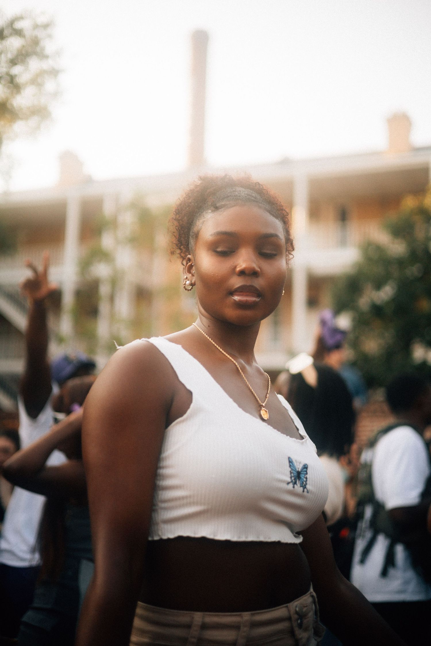 A sequence of photos showing someone in a white tank top with a butterfly design against a blurred background.  USC Hip Hop Wednesday