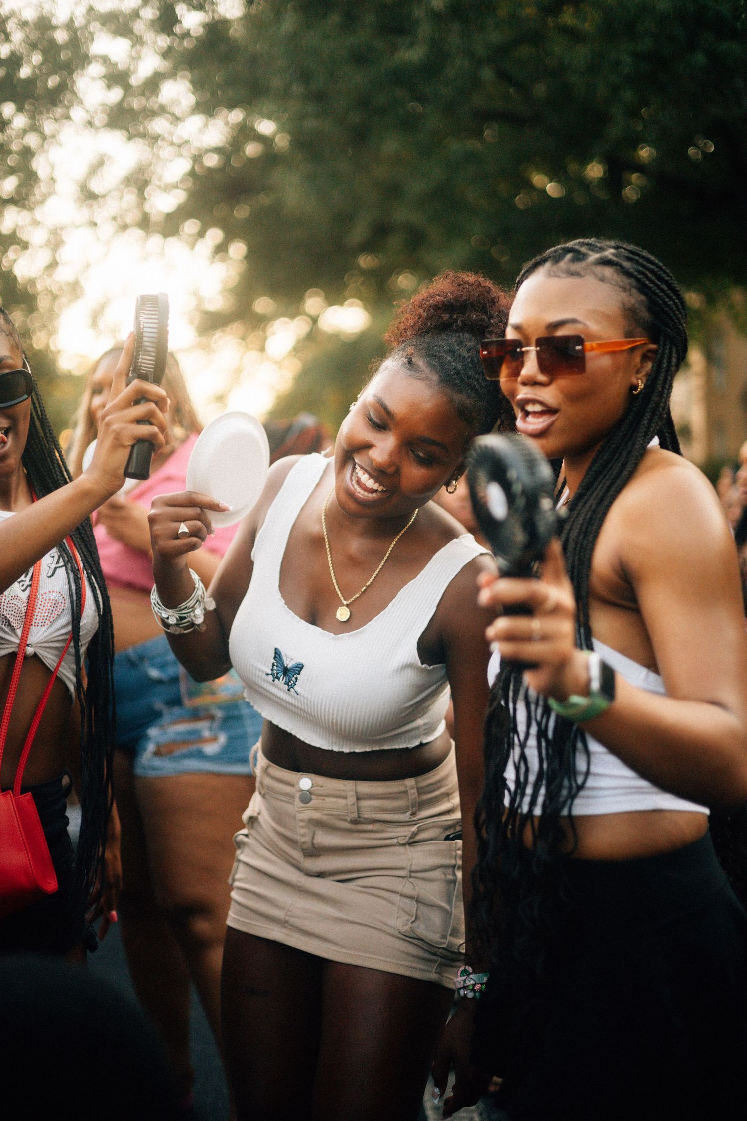 Group of friends enjoying outdoor music festival capturing memories with phones and cameras at sunset. USC Hip Hop Wednesday