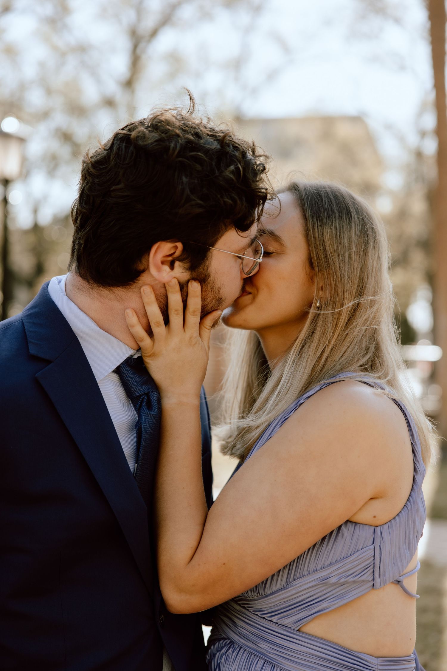 Romantic couple sharing intimate kiss outdoors during golden hour.