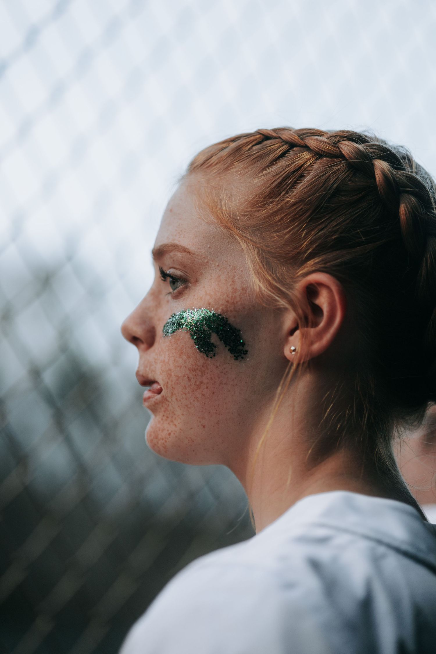 DFHS Profile view of someone with braided hair and sparkly teal makeup around their eye.