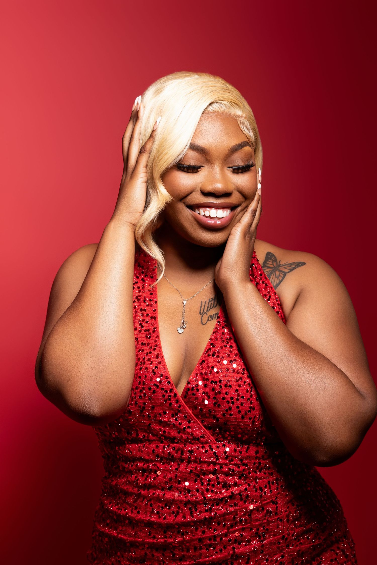 Glamour portrait in a sparkly red dress against a red background.