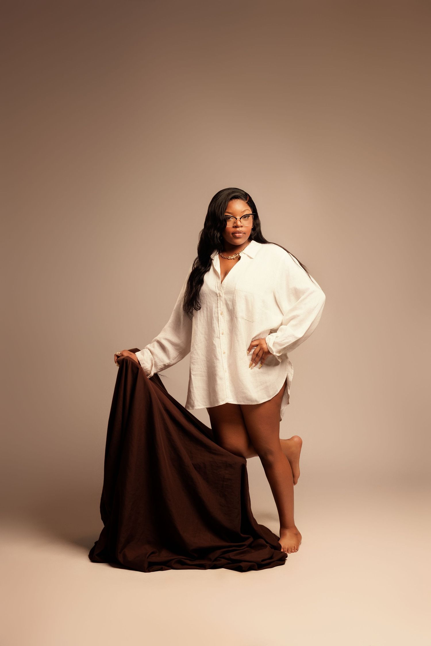 A series of artistic studio portraits showing a person in a brown skirt and white top in various seated poses against a neutral background.