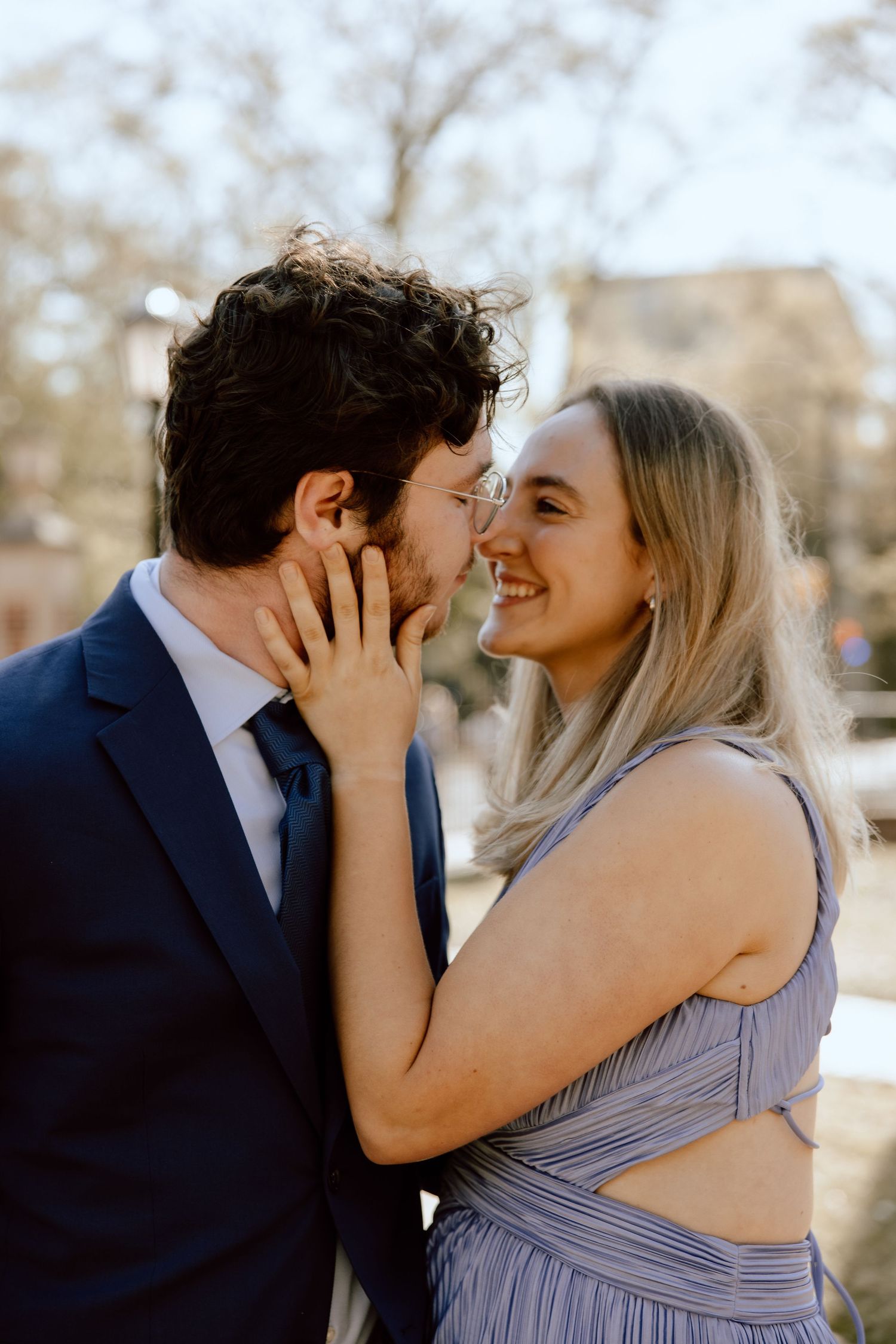 Couple shares intimate moment in formal attire during outdoor photoshoot.