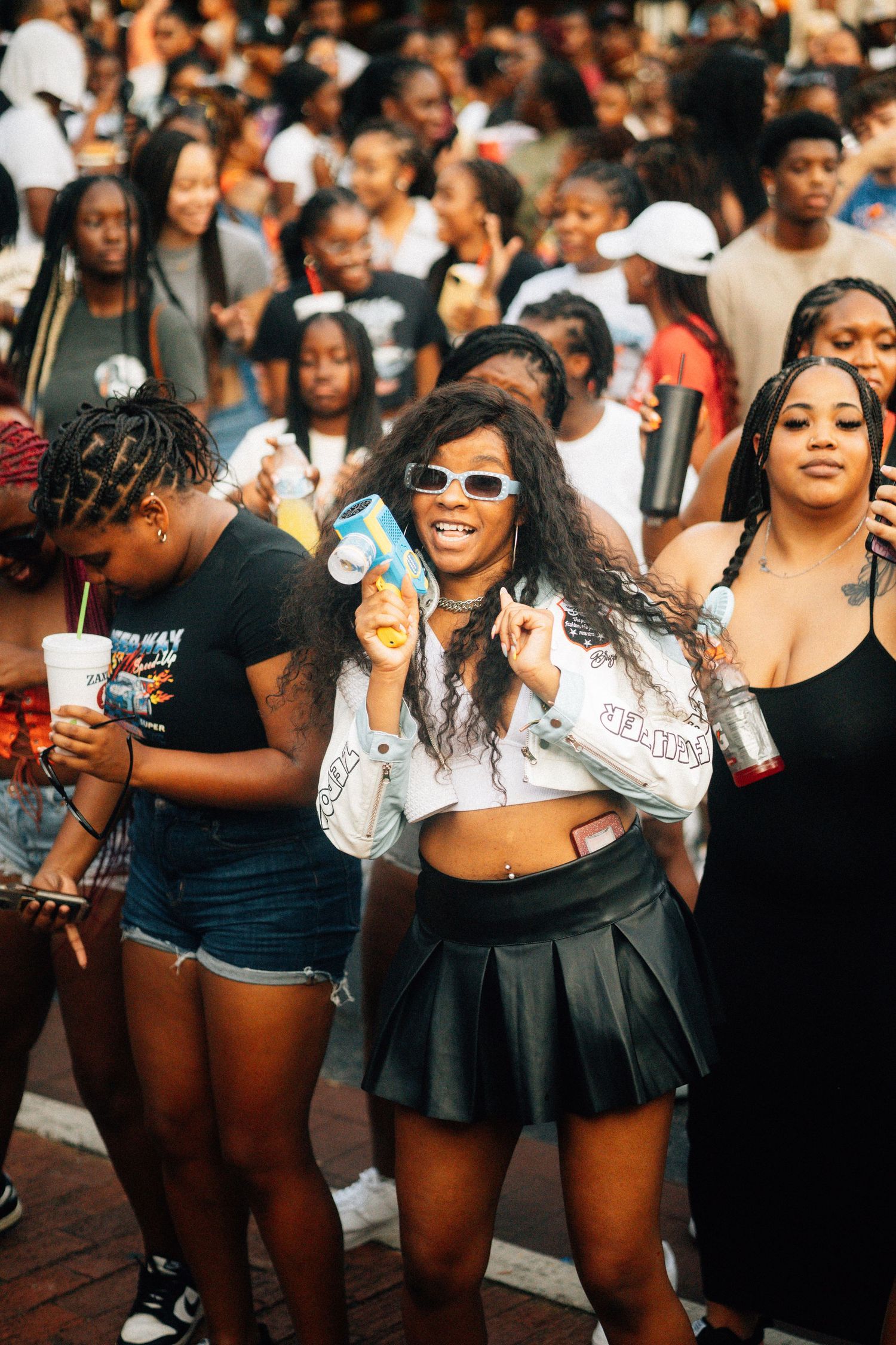 Lively crowd enjoying a summer festival with attendees dancing and socializing in summer outfits and sunglasses.USC Hip Hop Wednesday