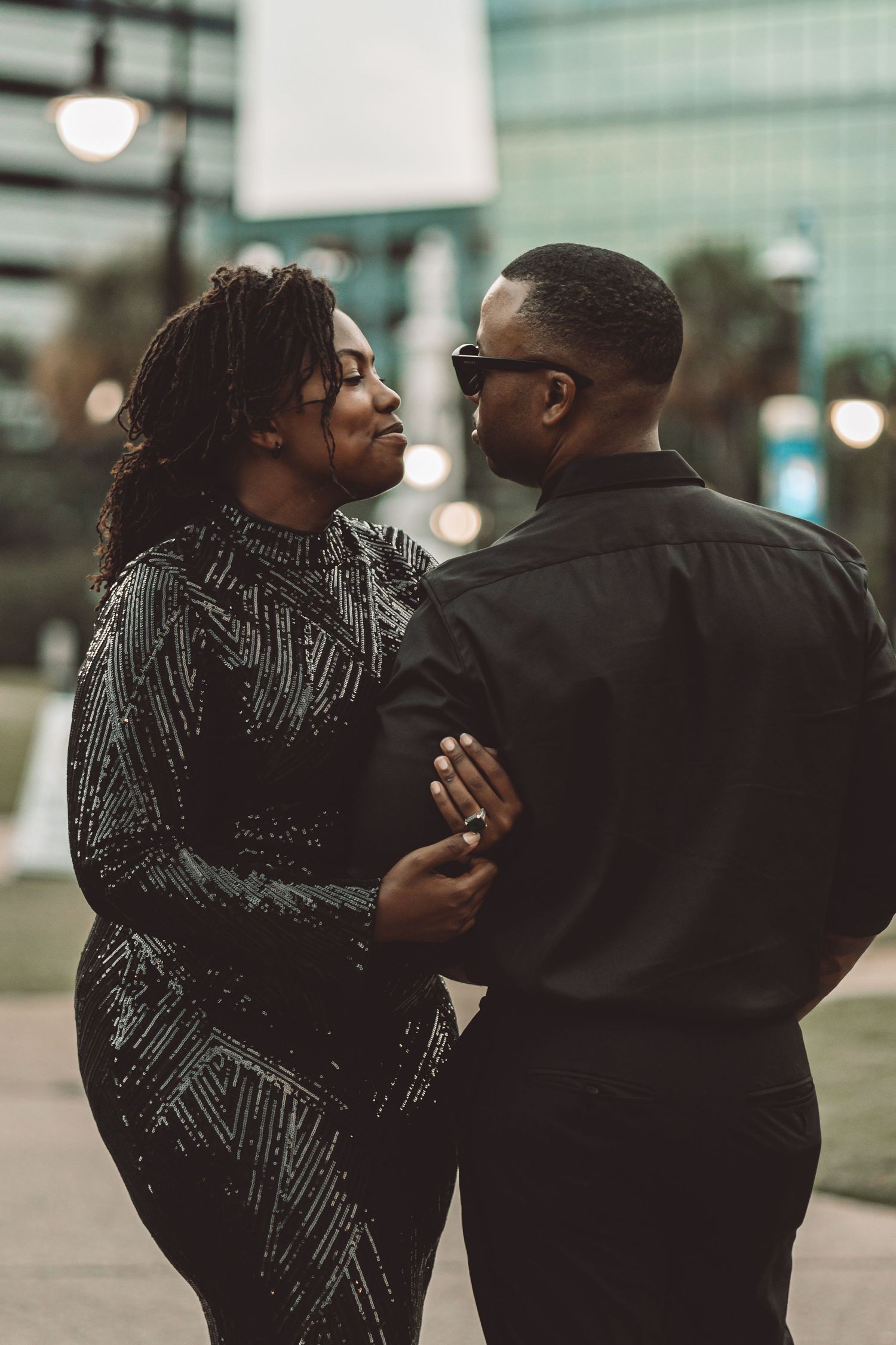 Intimate couple shares a romantic moment in evening urban setting.