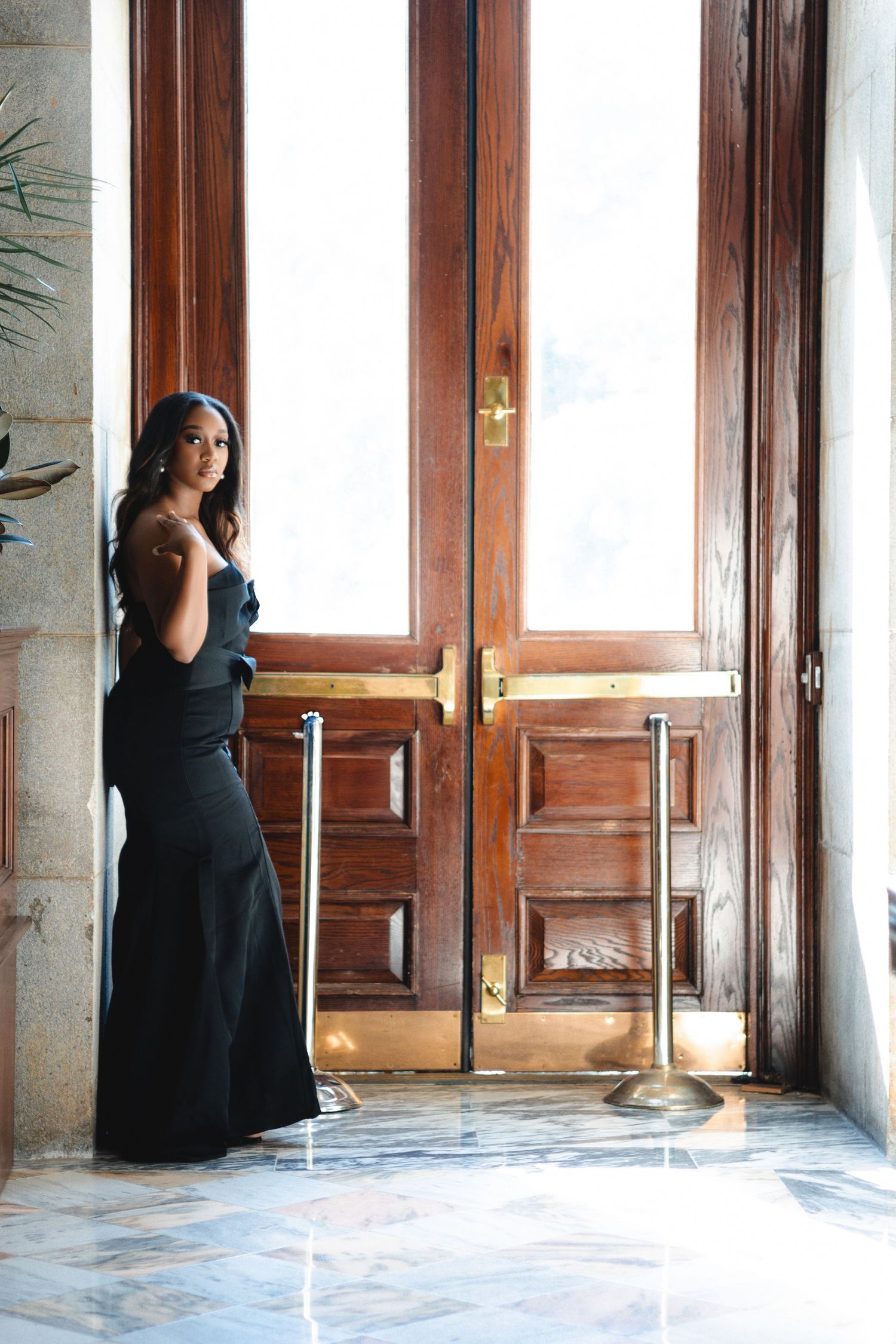 Artistic series of poses in black dress against vintage wooden interior and windows.