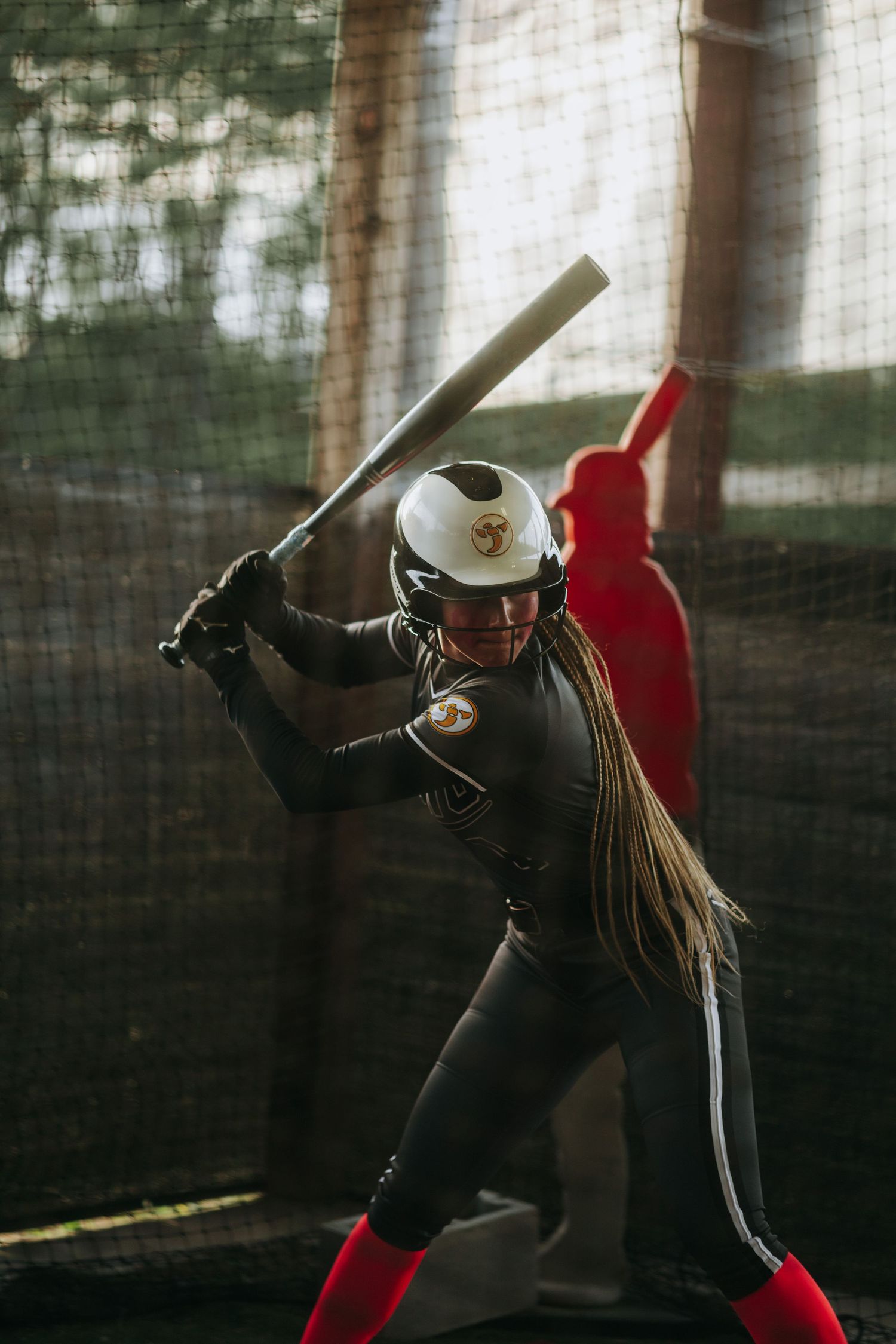 Irmo HS Softball player in dark uniform takes batting stance during practice.