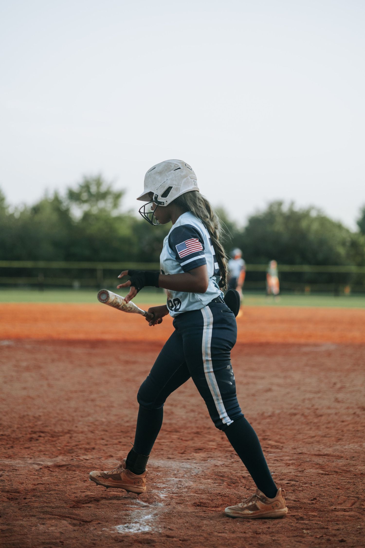 A softball player in motion readies to swing the bat during practice.