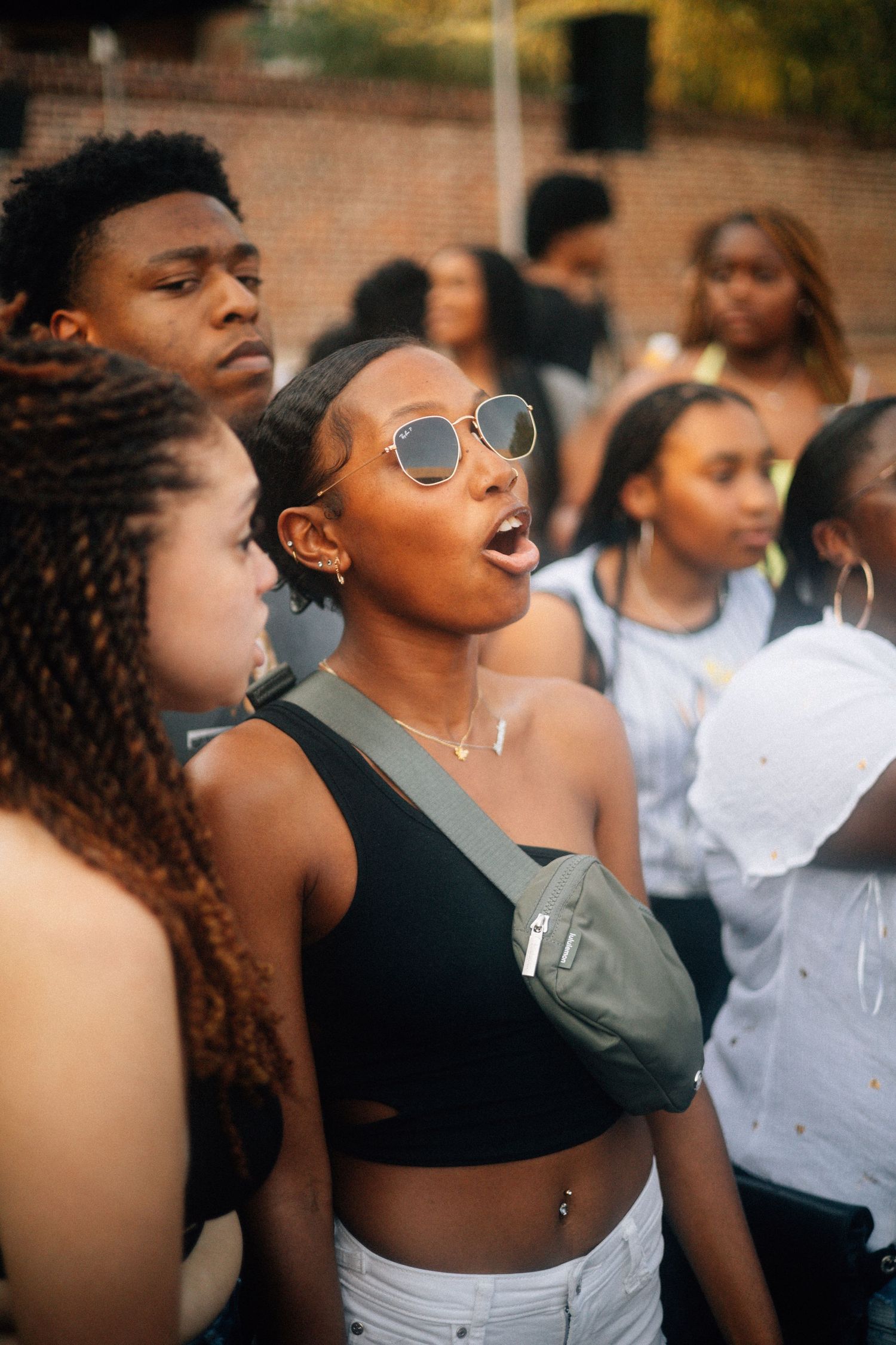 Group of energetic young people enjoying a summer gathering outdoors with one wearing sunglasses and a crop top.  USC Hip Hop Wednesday