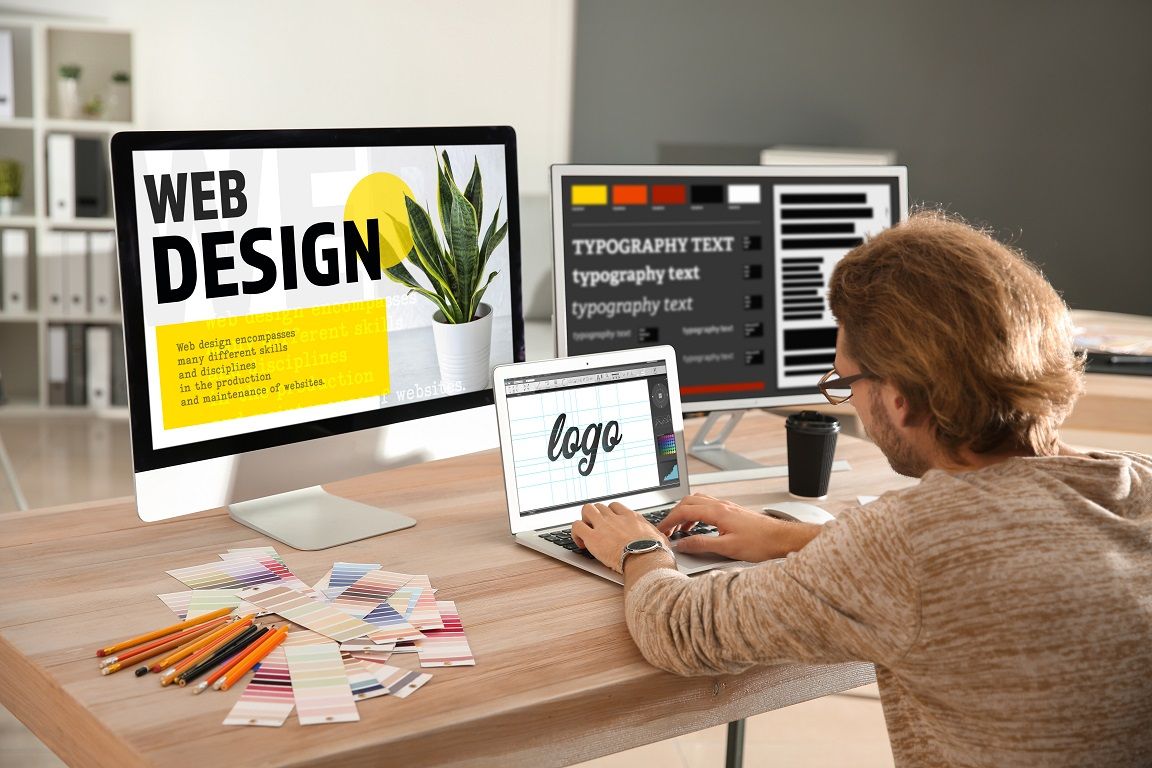 Web design workspace with computer monitor showing typography and design elements.