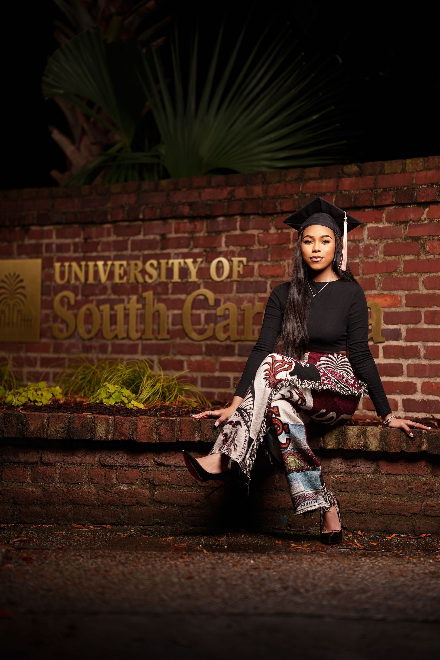 A series of graduation photos showing someone sitting against a brick wall in formal attire and cap at dusk.