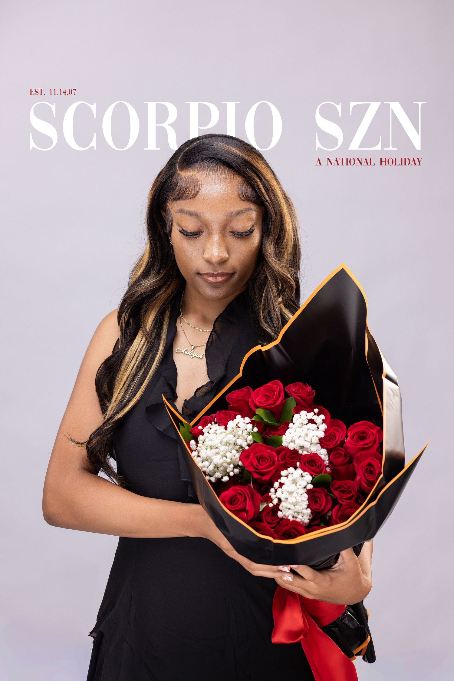 A person in black holding a stunning bouquet of red roses with white baby's breath flowers against a light background.