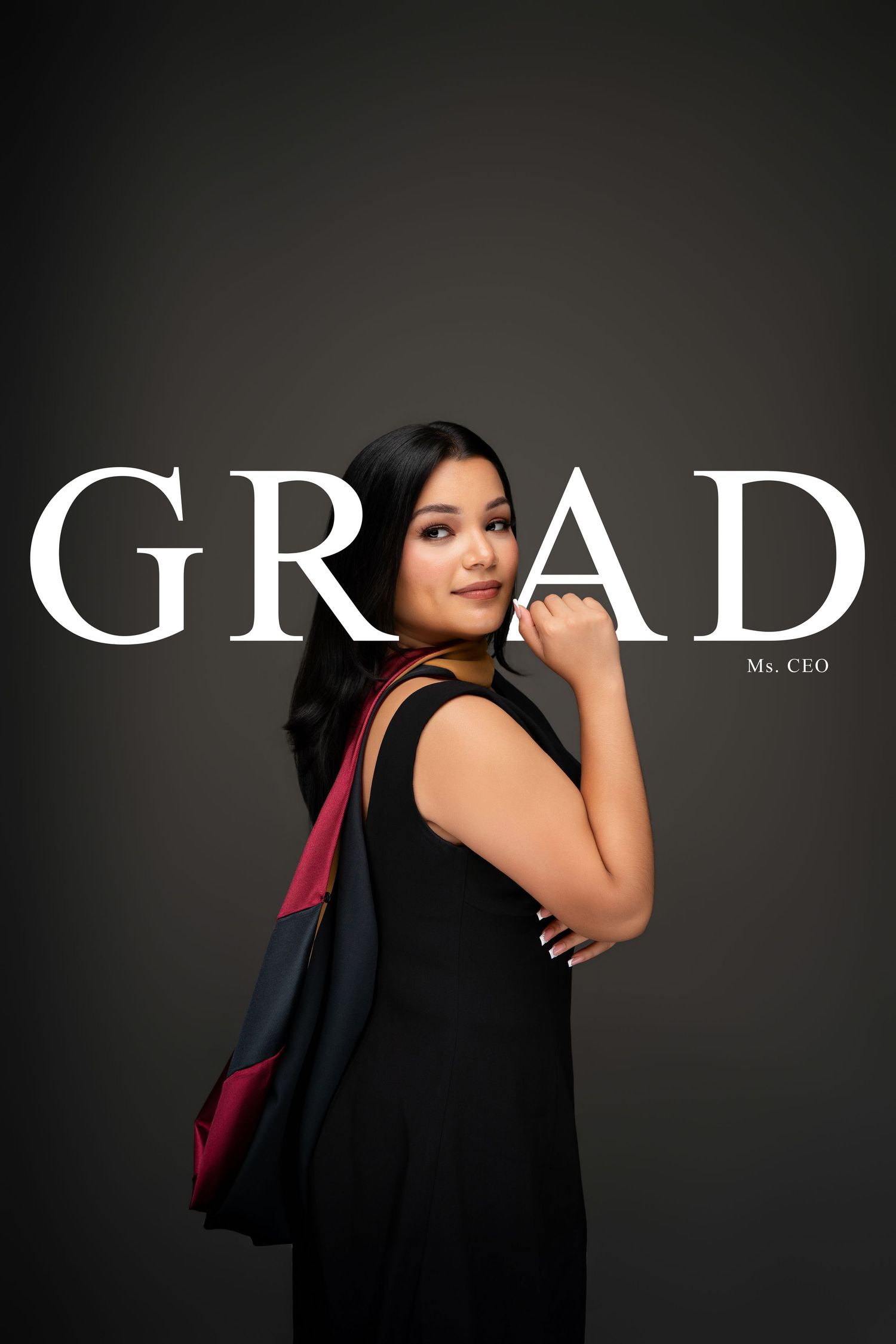 Young woman in black dress with graduation cap and backpack posing in front of GRAD text backdrop.