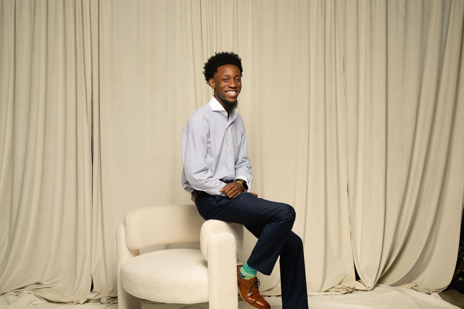 Modern photo studio setup with white backdrop curtains and lighting equipment.