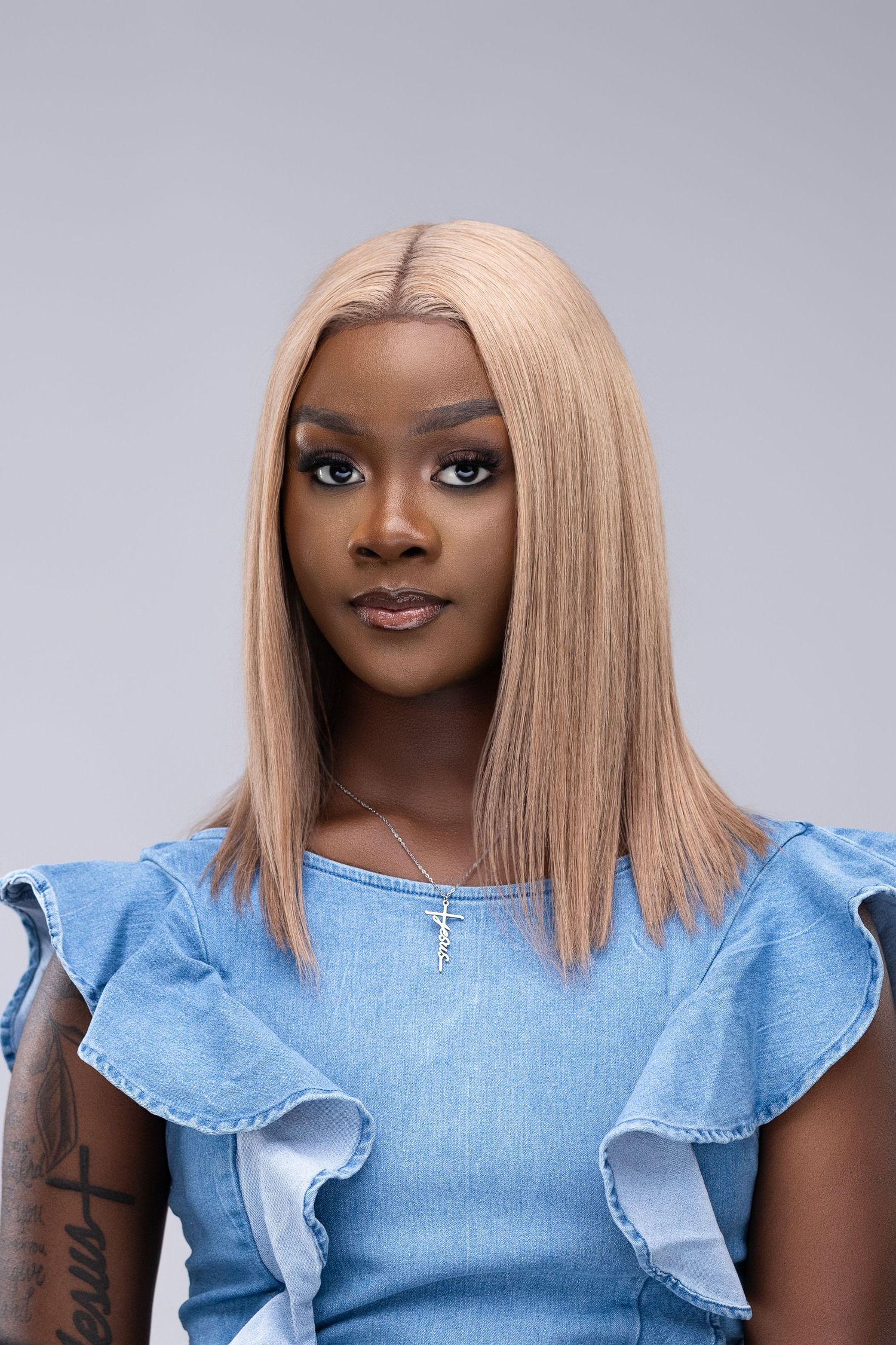 Collage of person wearing denim ruffle sleeve top and blonde hair styled straight against gray background.