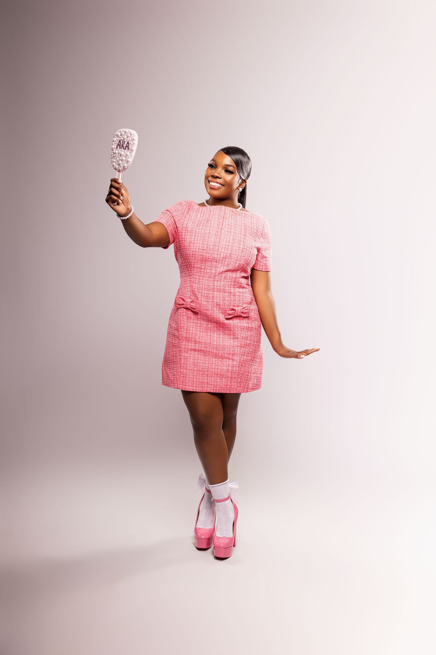 A figure in a pink textured dress strikes dynamic poses in a studio setting.