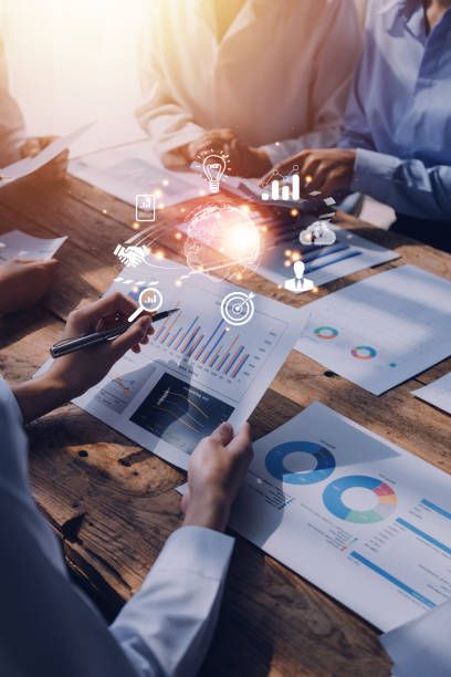 Business analytics data charts and graphs on wooden desk with person reviewing financial reports.