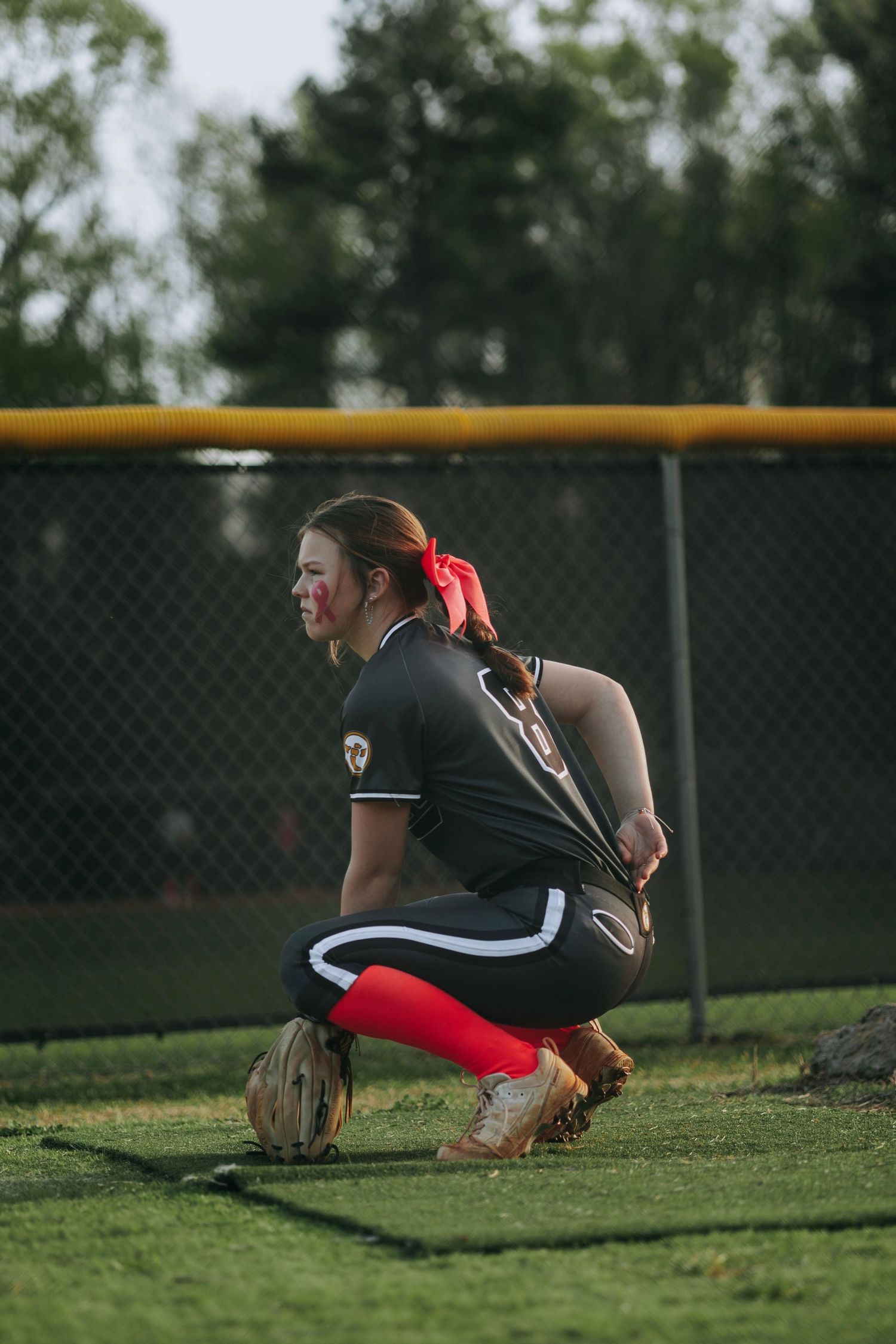 Irmo HS Softball player crouches in ready position on field.