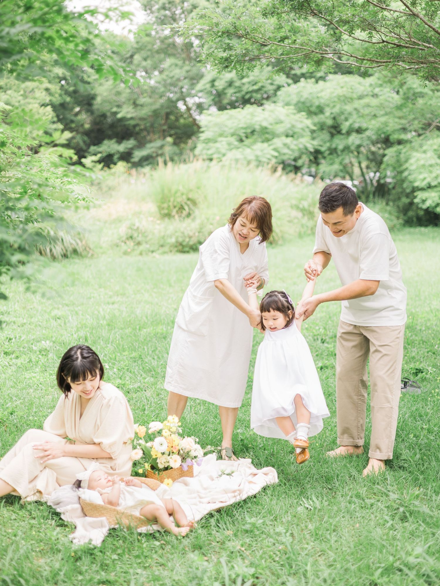 A picturesque family picnic scene in a lush green park with floral arrangements.