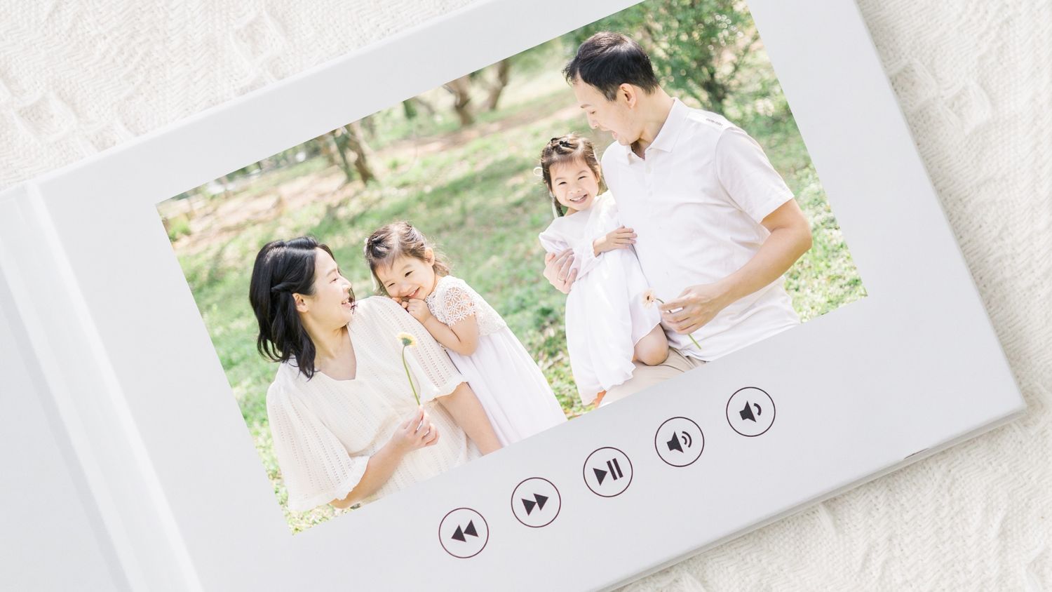 A photo album spread showing candid outdoor family moments with media control buttons.