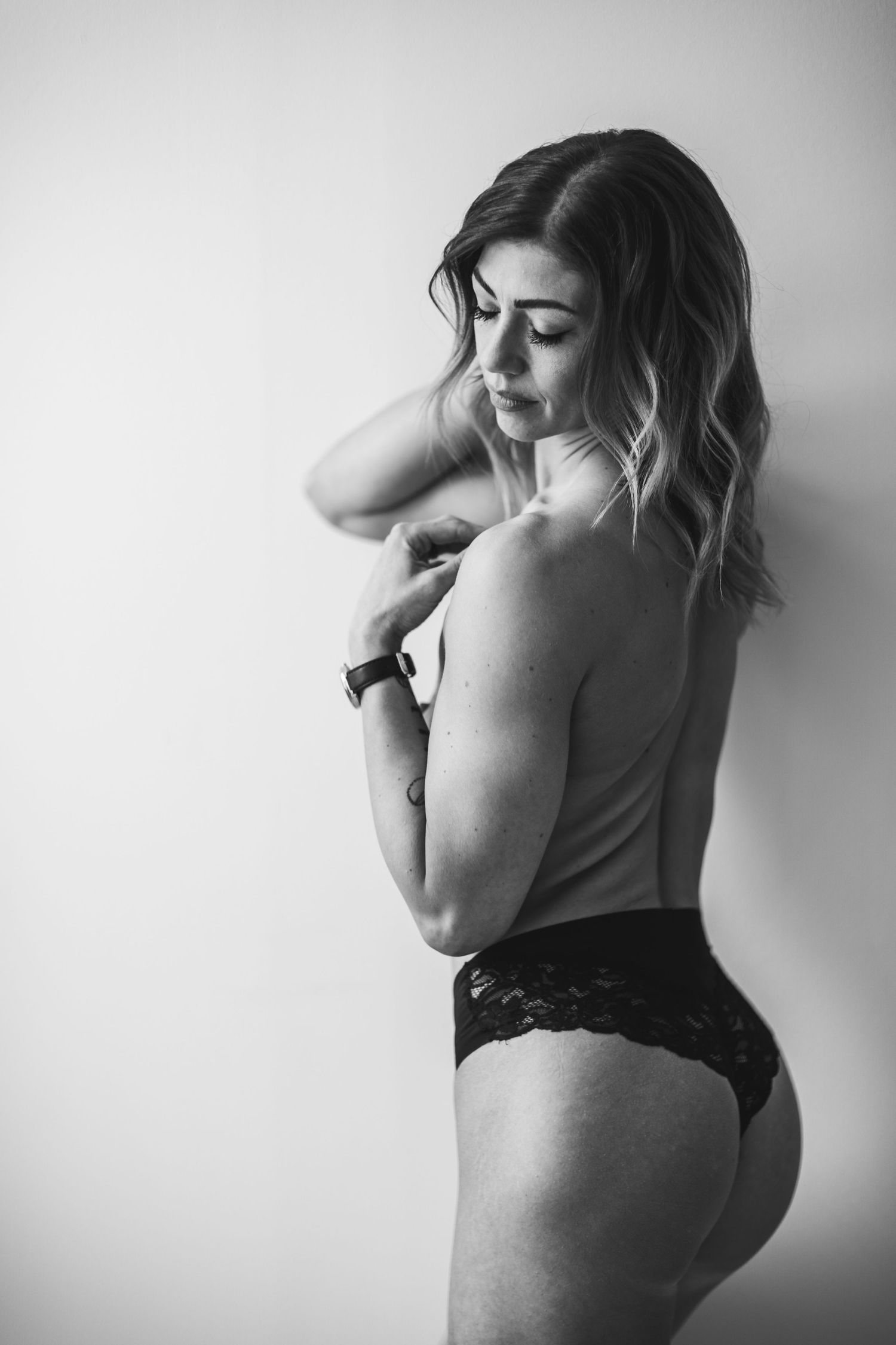 Nainen yläosattomissa boudoir-kuvauksessa