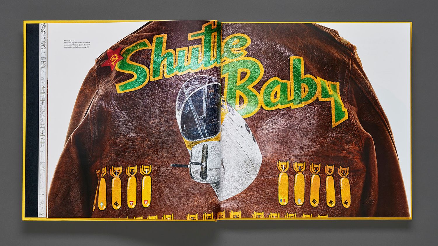 Open Bomber Boys book spread featuring a leather flight jacket painted with the Shute Baby nose art, bomb tally marks and a gas mask.