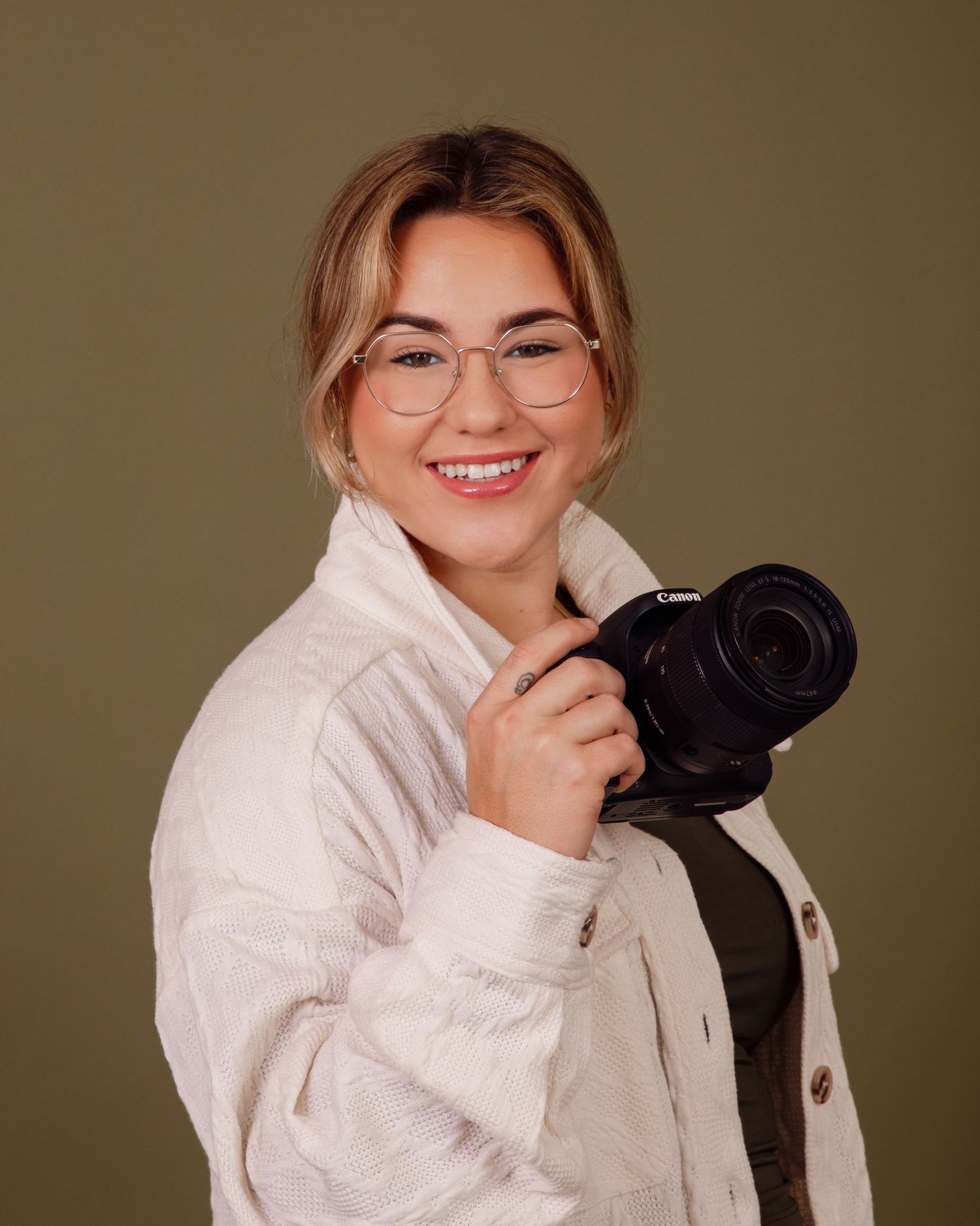 Portrait series showing a cozy white sweater and casual poses against a warm brown backdrop.