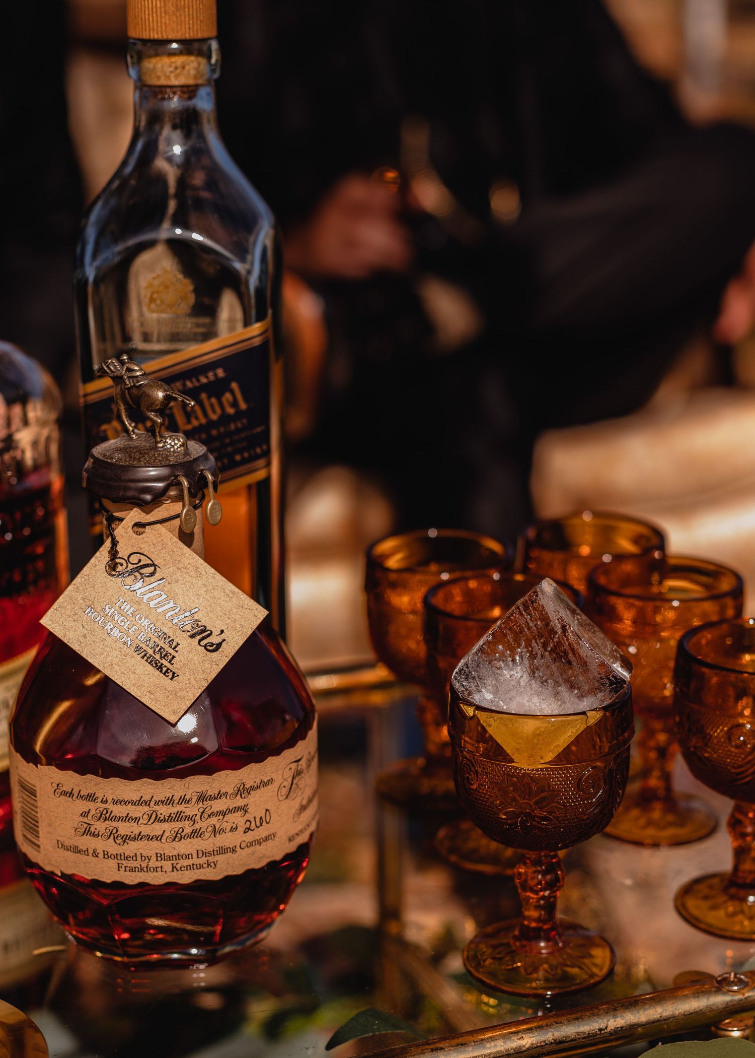 Vintage-style amber glasses with handwritten notes and drinks on a dark wooden table.