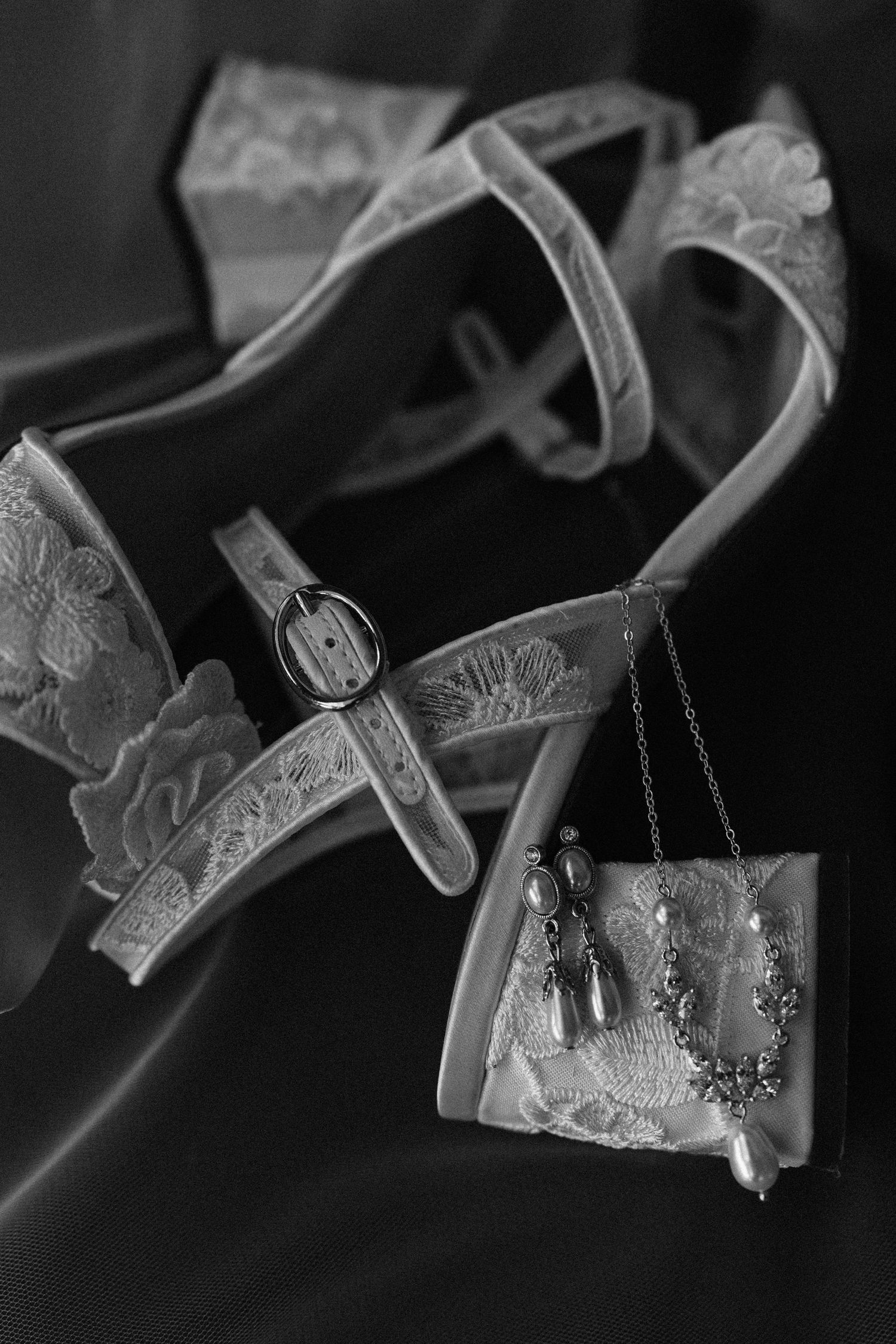 Artistic black and white photo series showing delicate lace lingerie hanging on hangers in moody lighting.