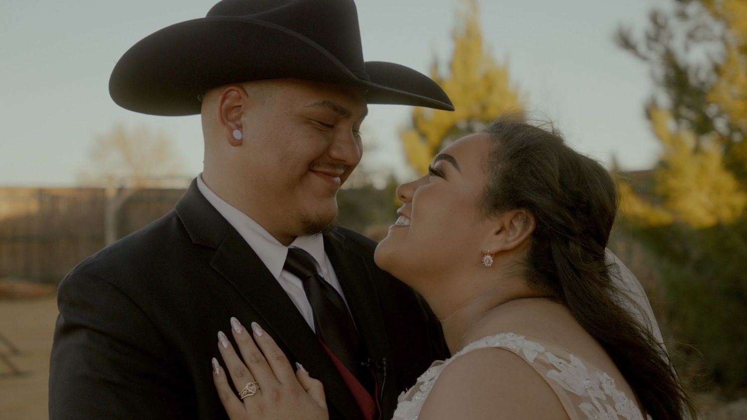 Western themed wedding couple share intimate moment at sunset.