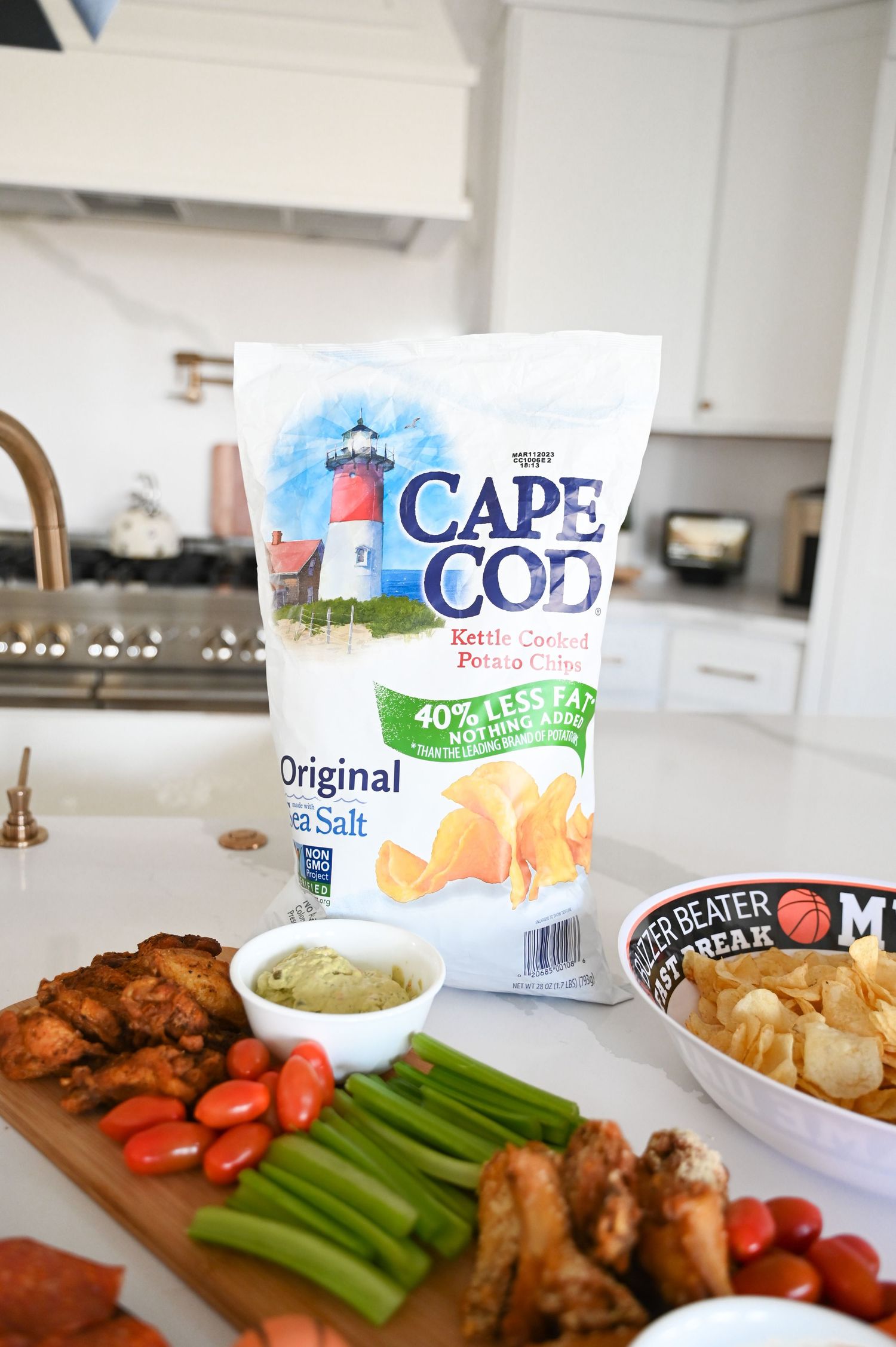 Cape Cod Original Sea Salt kettle cooked potato chips displayed with charcuterie board of veggies and wings.