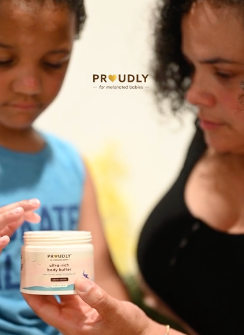 Woman and child examining Proudly ultra-rich body butter, a skincare product designed for melanated babies.
