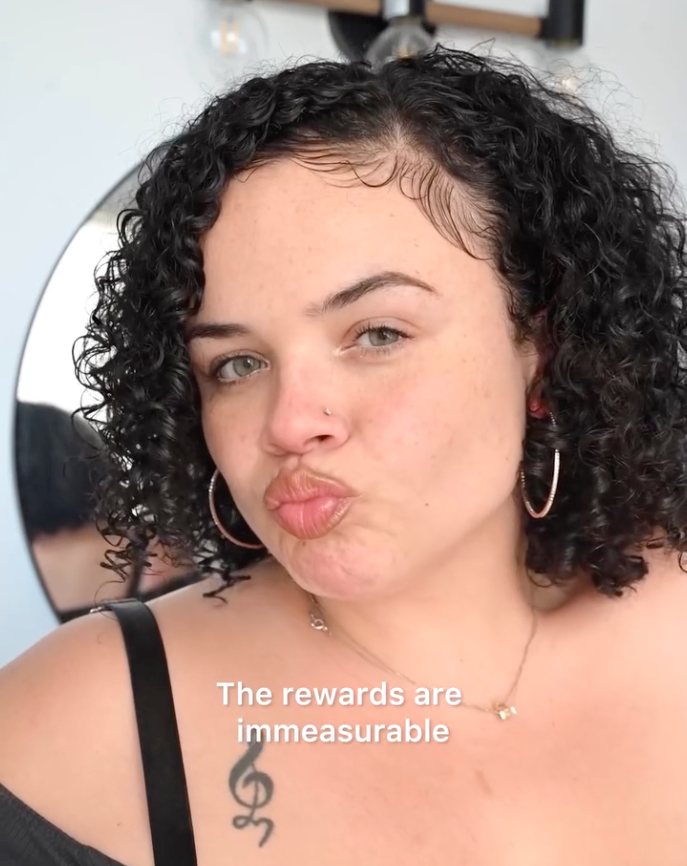 Young woman with curly black hair and hoop earrings making a pouty face with text overlay reading the rewards are immeasurable.
