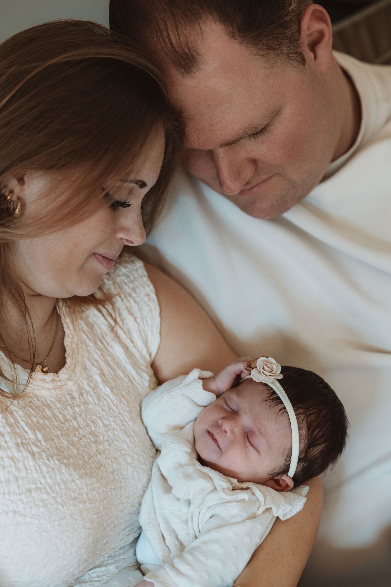 Pure newbornfoto van een pasgeboren baby in een warme, huiselijke omgeving.