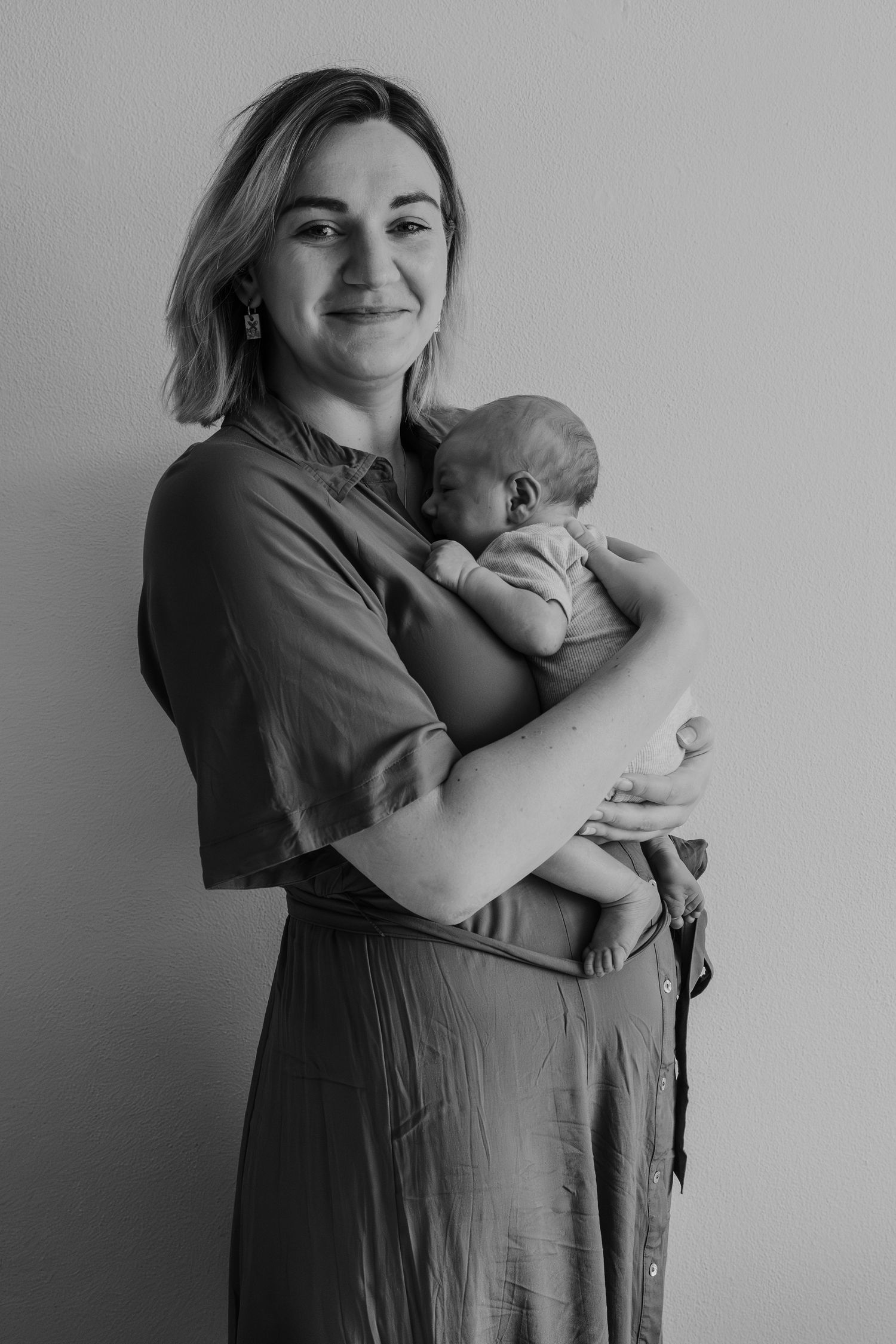 Pure newbornfoto van een pasgeboren baby in een warme, huiselijke omgeving.