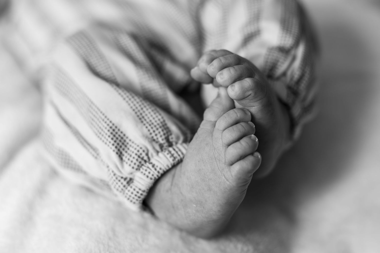 Pure newbornfoto van een pasgeboren baby in een warme, huiselijke omgeving.