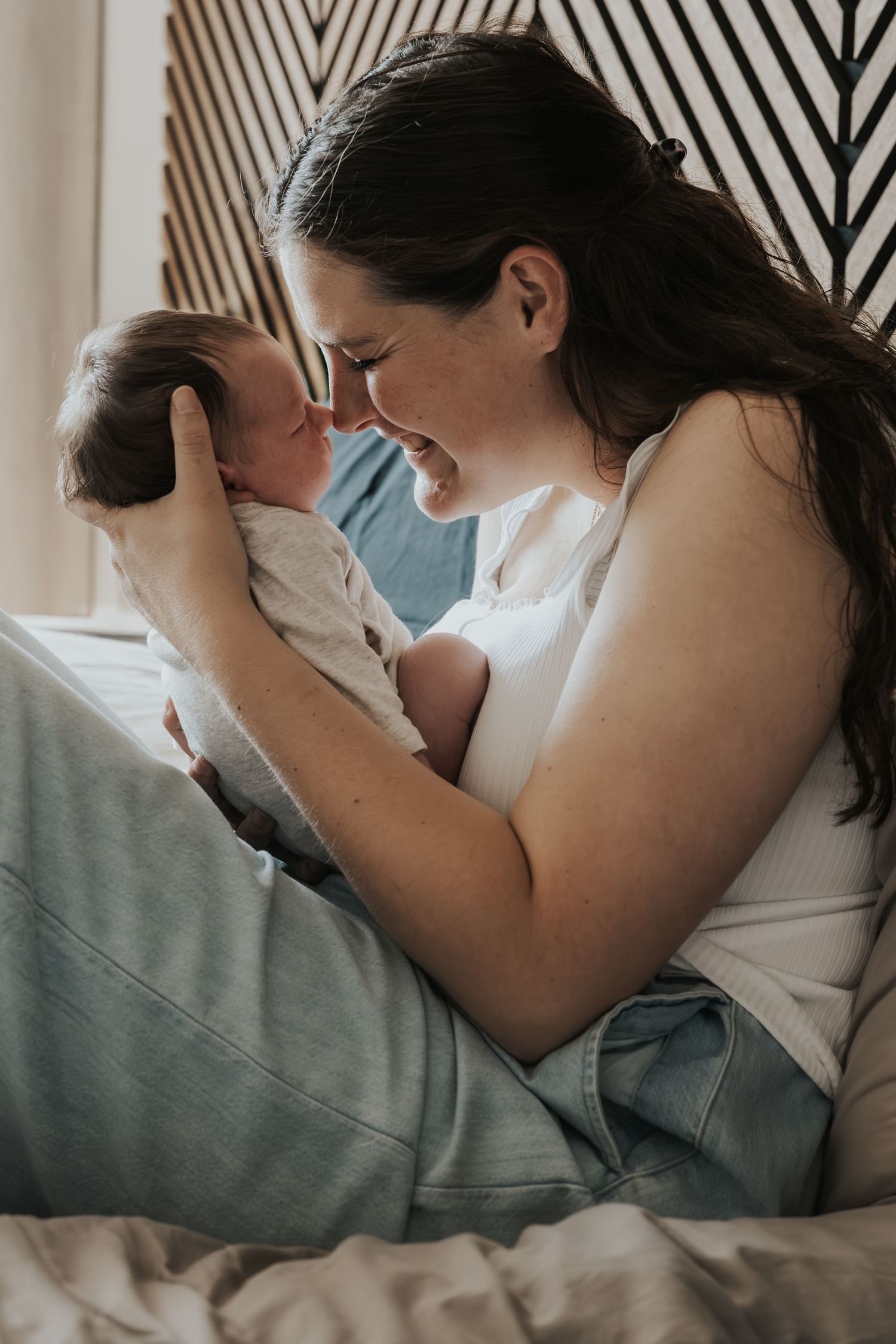 Pure newbornfoto van een pasgeboren baby in een warme, huiselijke omgeving.