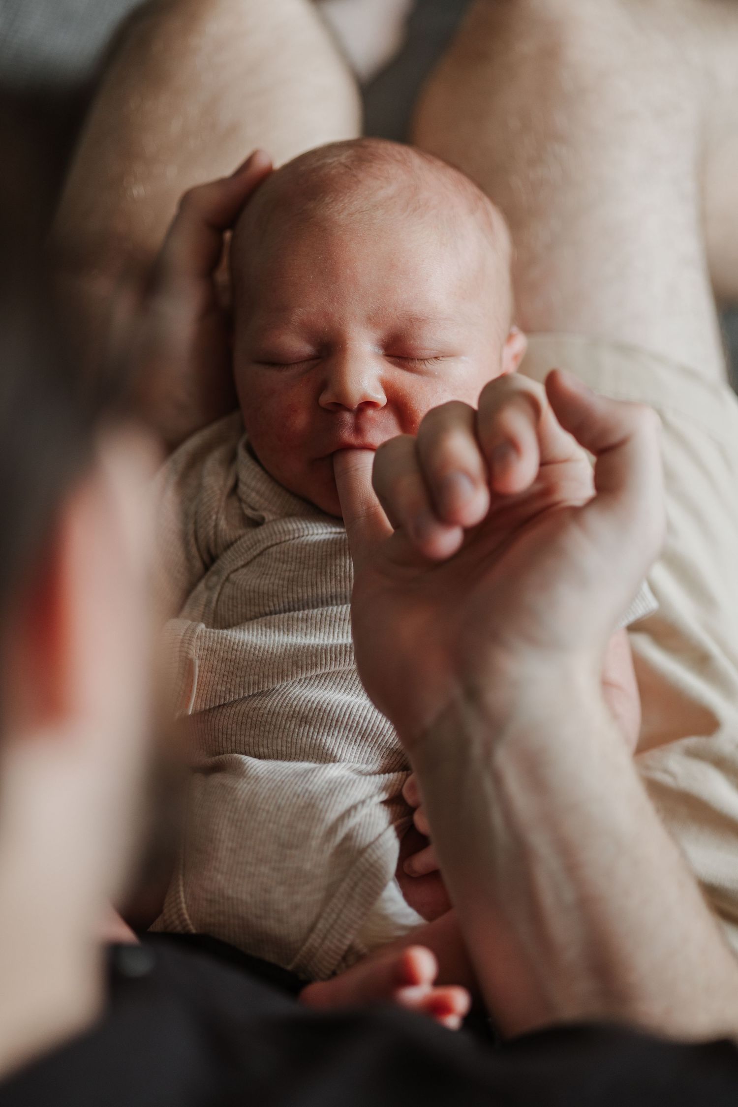 Pure newbornfoto van een pasgeboren baby in een warme, huiselijke omgeving.