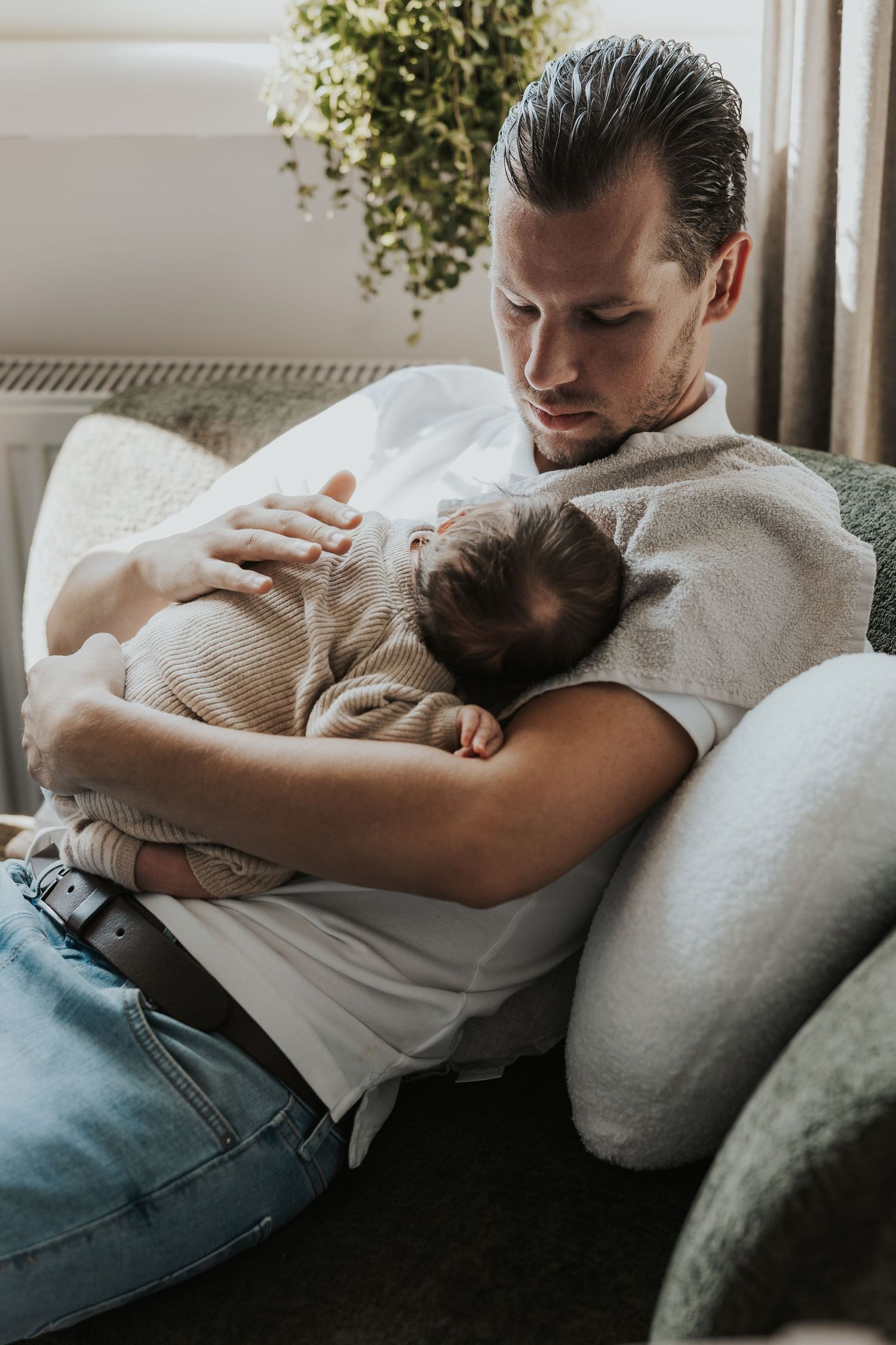 Pure newbornfoto van een pasgeboren baby in een warme, huiselijke omgeving.