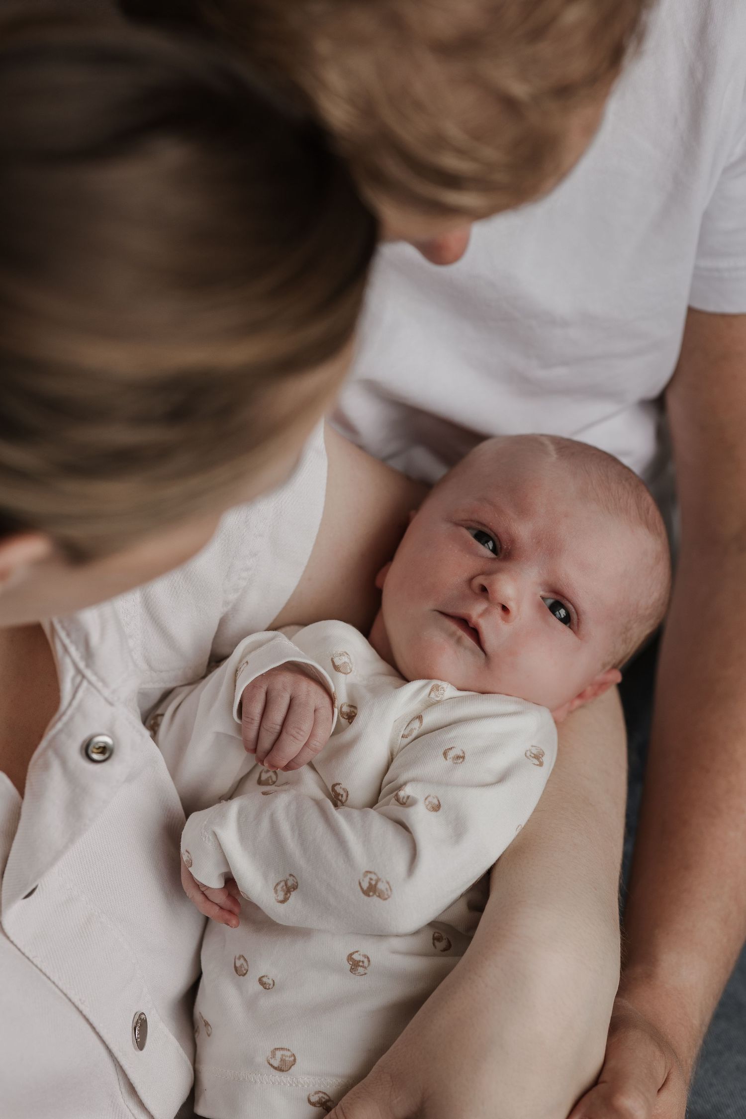 Pure newbornfoto van een pasgeboren baby in een warme, huiselijke omgeving.