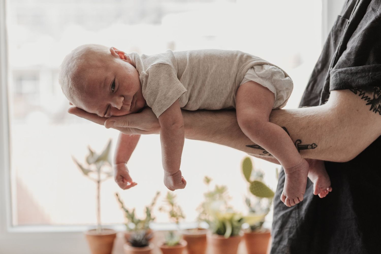 Pure newbornfoto van een pasgeboren baby in een warme, huiselijke omgeving.
