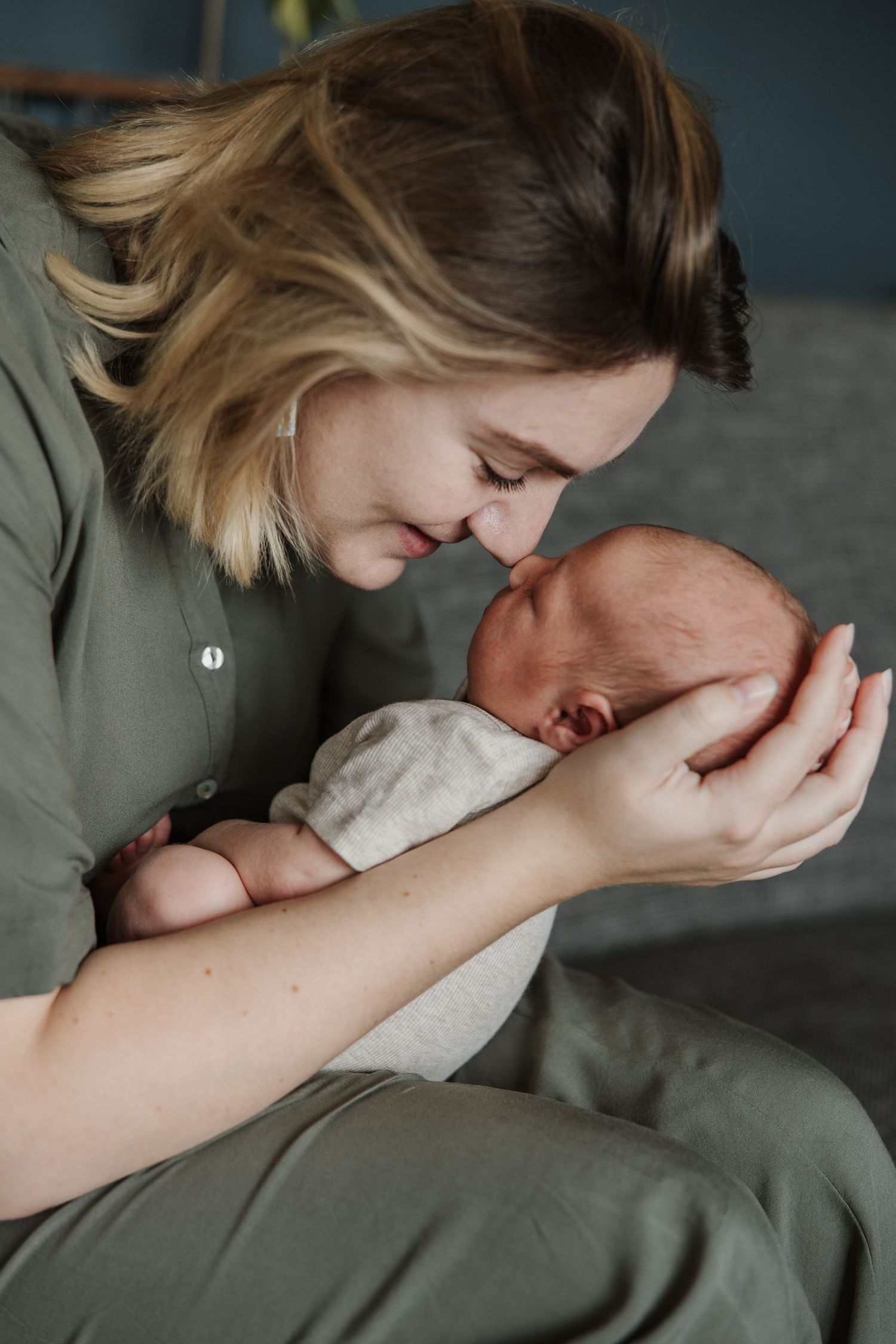 Pure newbornfoto van een pasgeboren baby in een warme, huiselijke omgeving.
