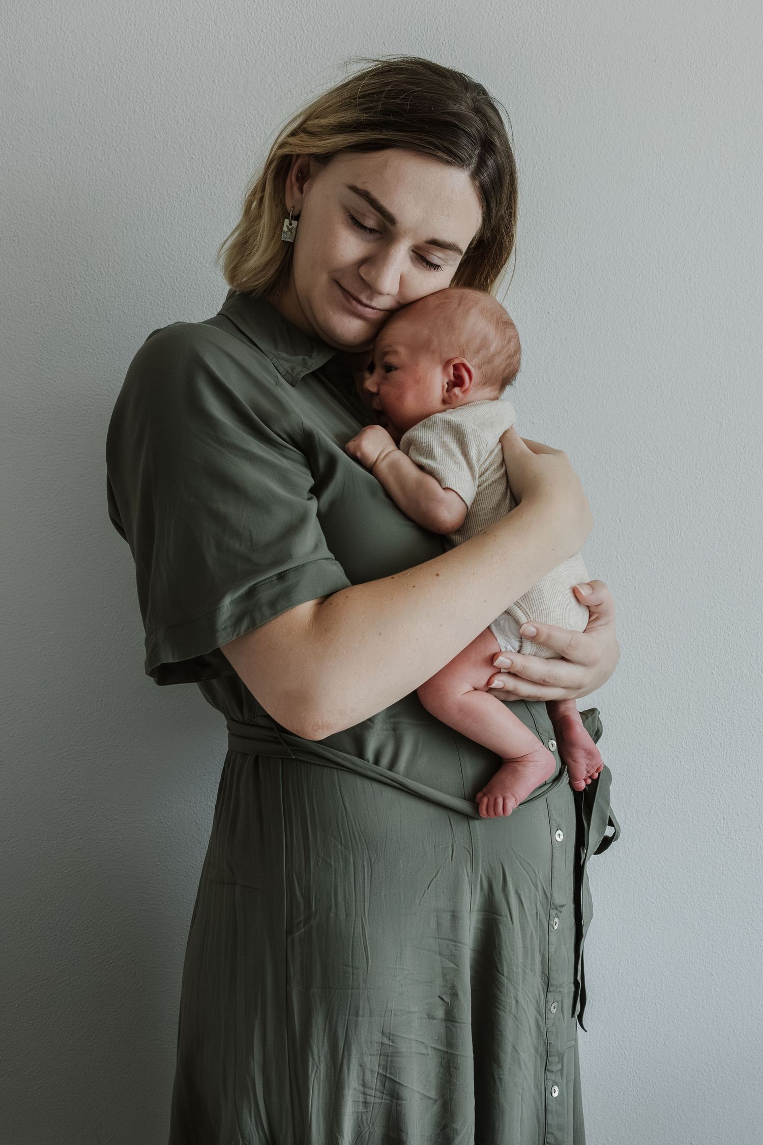 Pure newbornfoto van een pasgeboren baby in een warme, huiselijke omgeving.