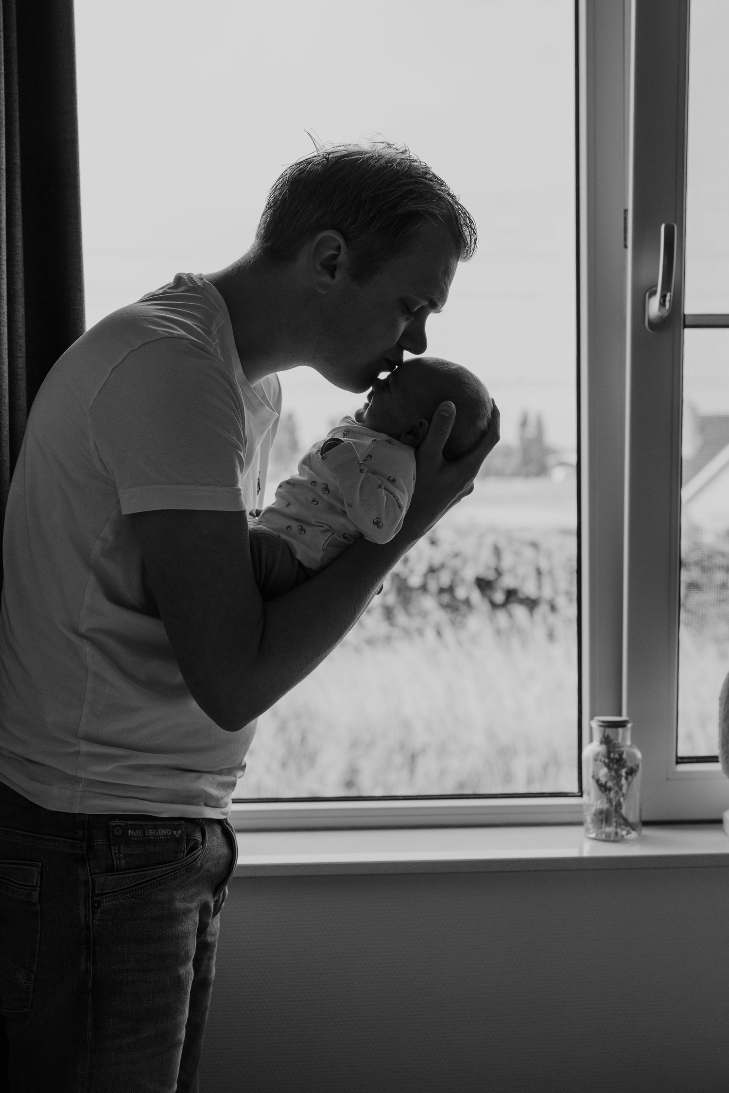 Pure newbornfoto van een pasgeboren baby in een warme, huiselijke omgeving.