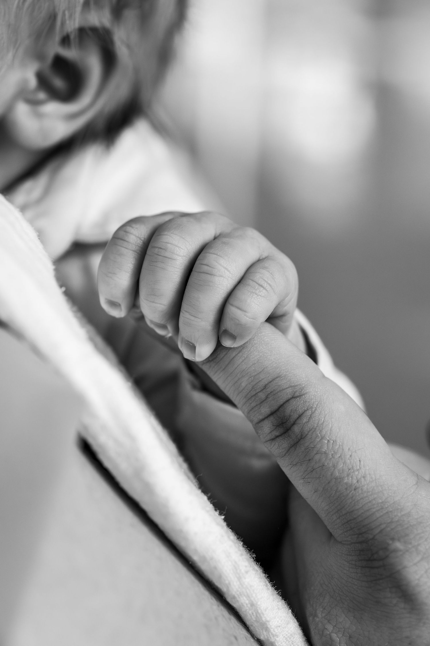 Pure newbornfoto van een pasgeboren baby in een warme, huiselijke omgeving.