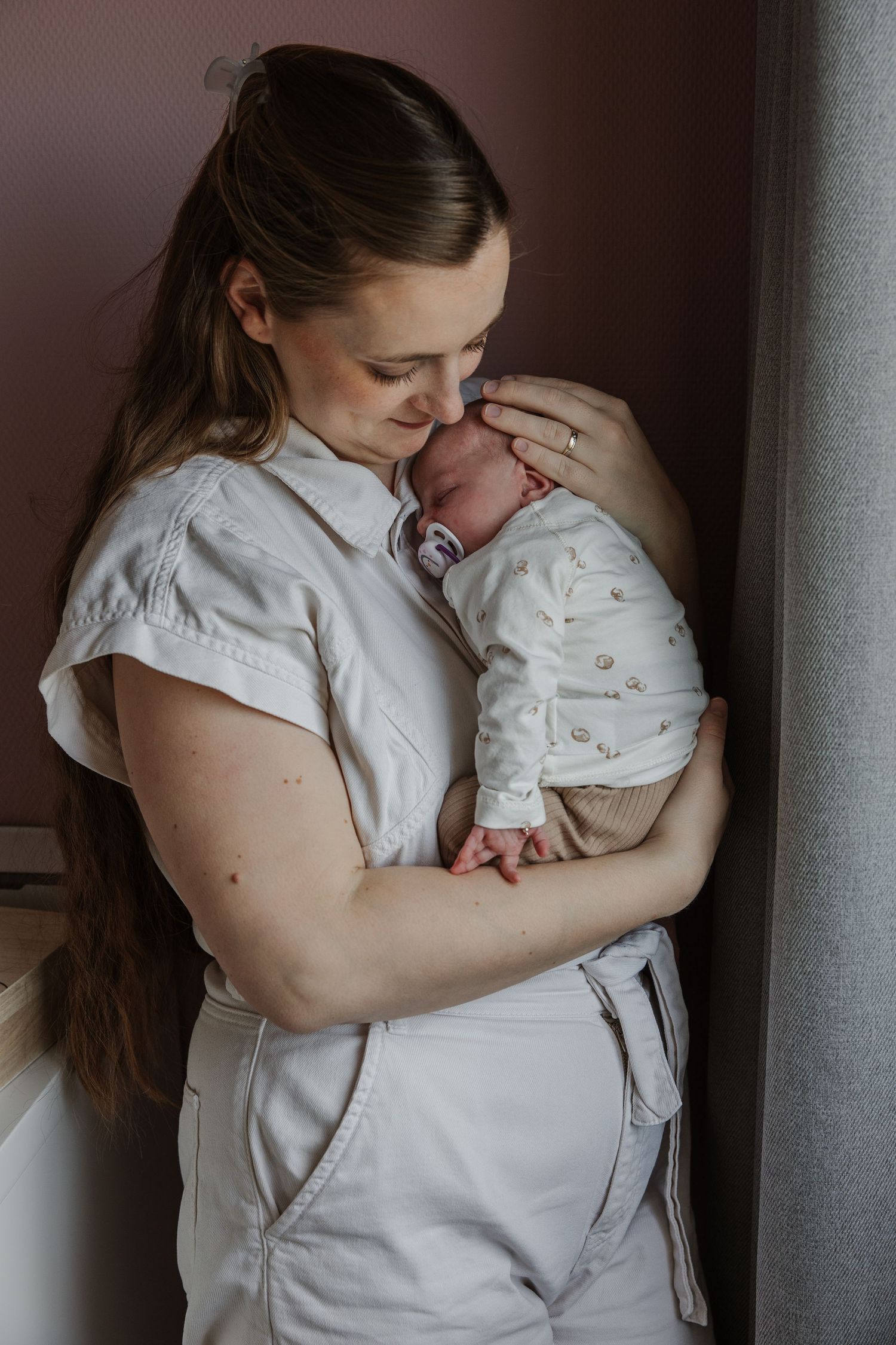 Pure newbornfoto van een pasgeboren baby in een warme, huiselijke omgeving.