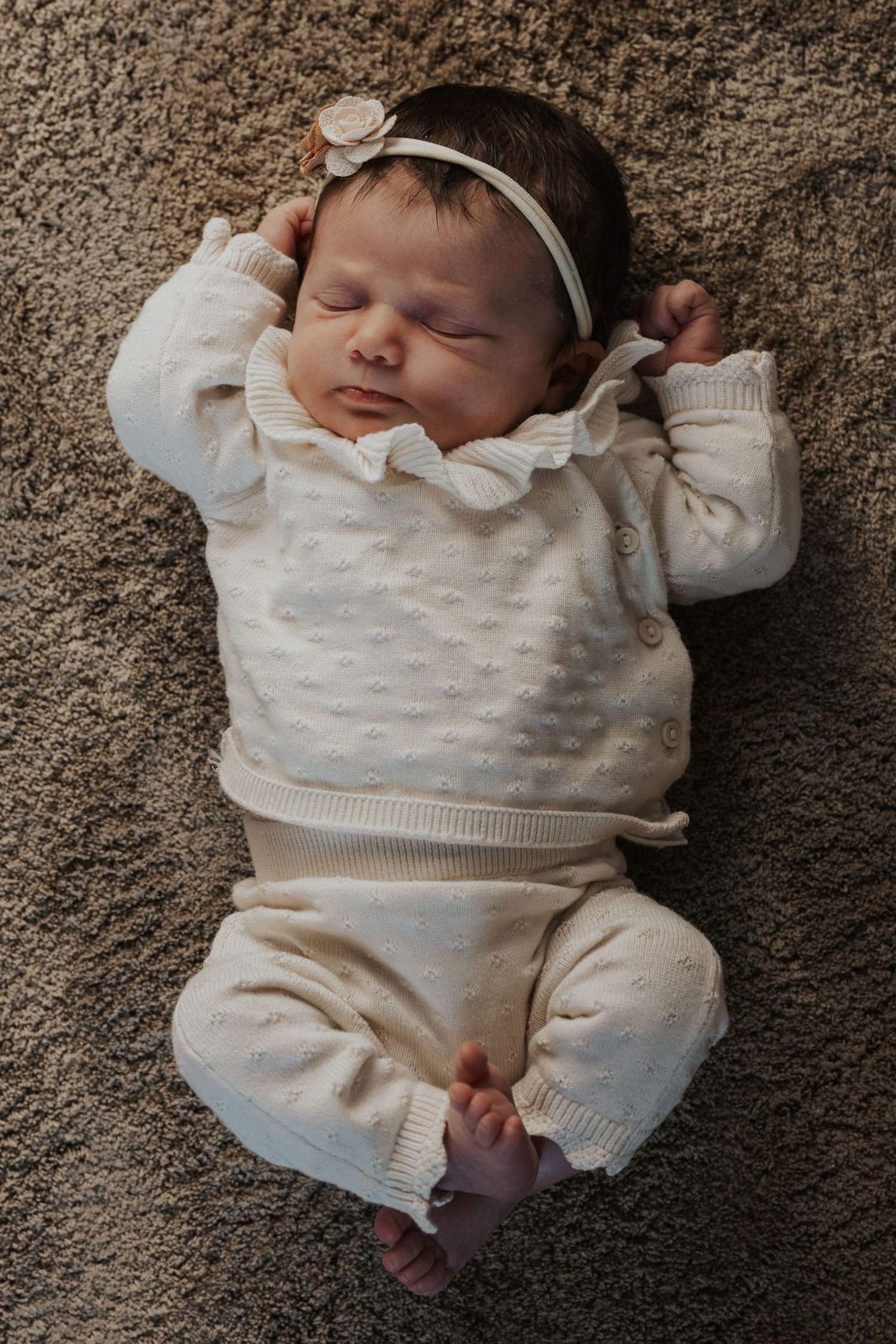 Pure newbornfoto van een pasgeboren baby in een warme, huiselijke omgeving.